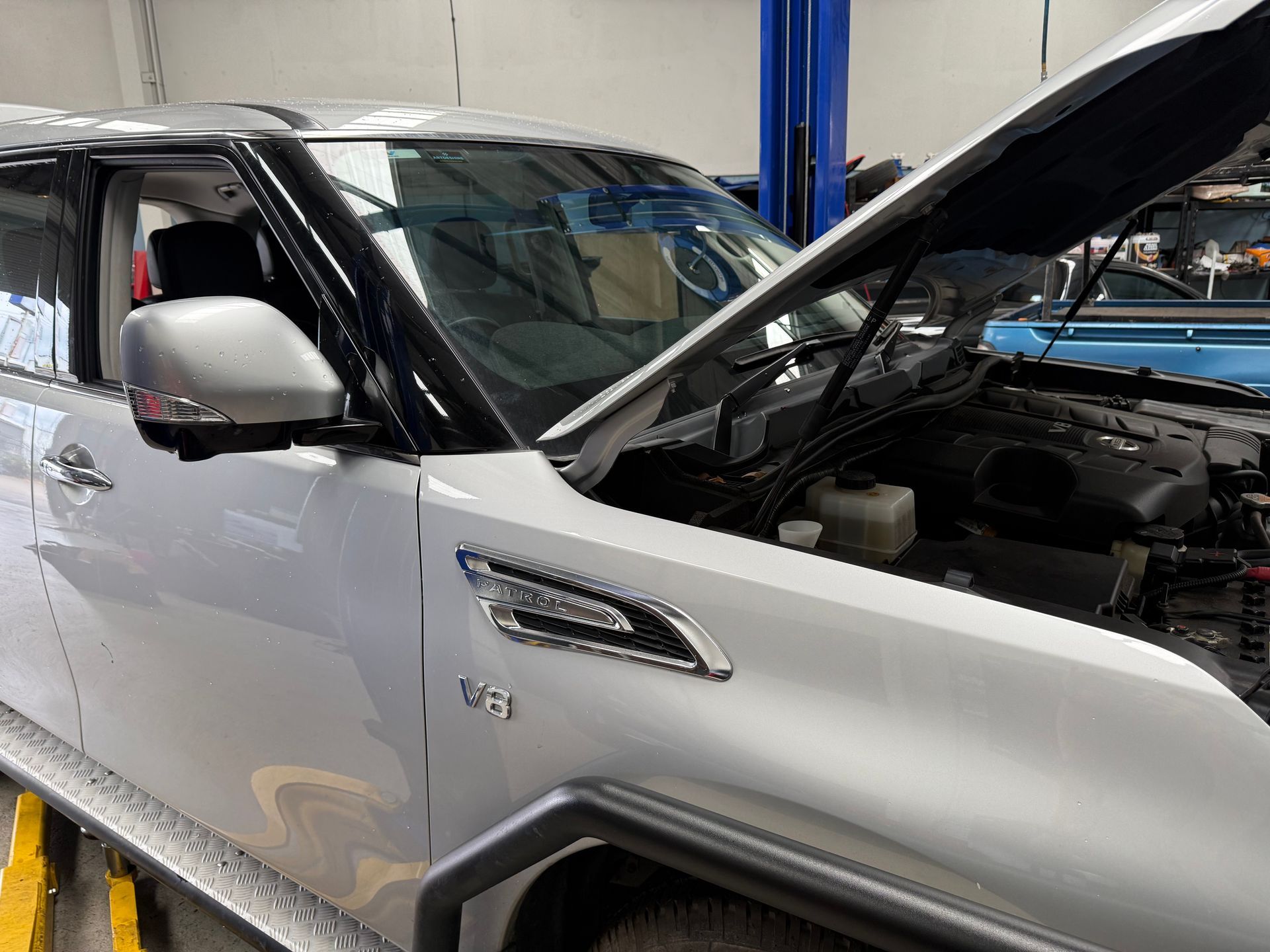Silver V8 SUV Parked in a Garage with Its Hood Raised, Revealing the Engine Bay — Mad Monkeys Mechanical in Cairns City, QLD