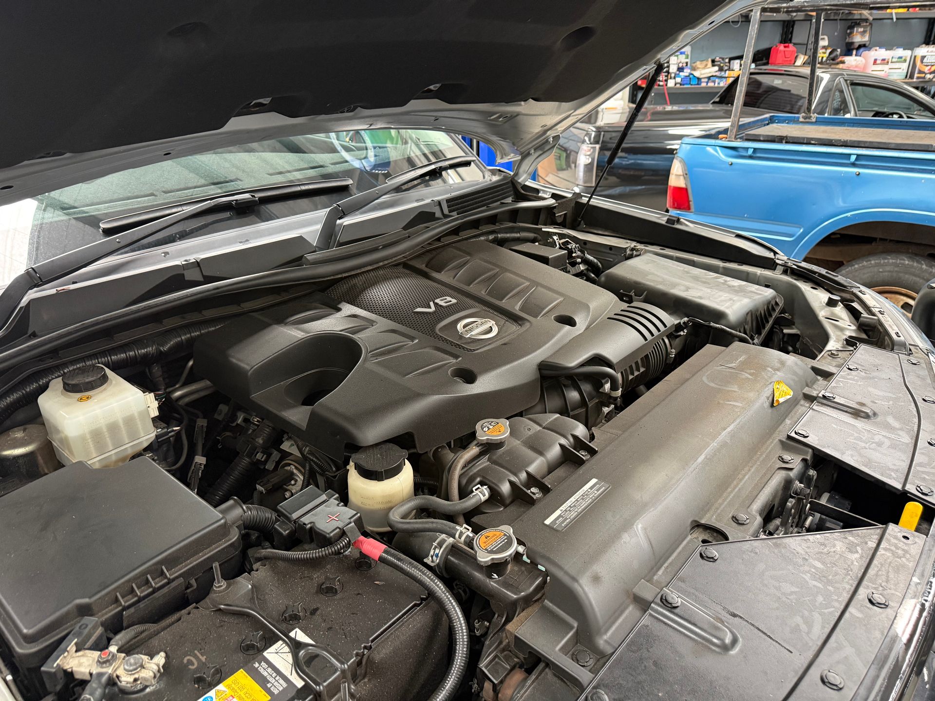 Open Hood Reveals the Engine Bay of a Modern Vehicle with a Nissan Engine Cover — Mad Monkeys Mechanical in Cairns City, QLD