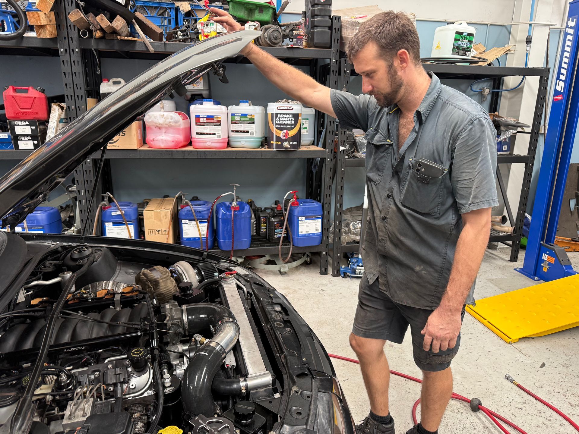 A Mechanic Standing in an Auto Repair Shop With His Hand on an Open Car Hood — Mad Monkeys Mechanical in Cairns City, QLD