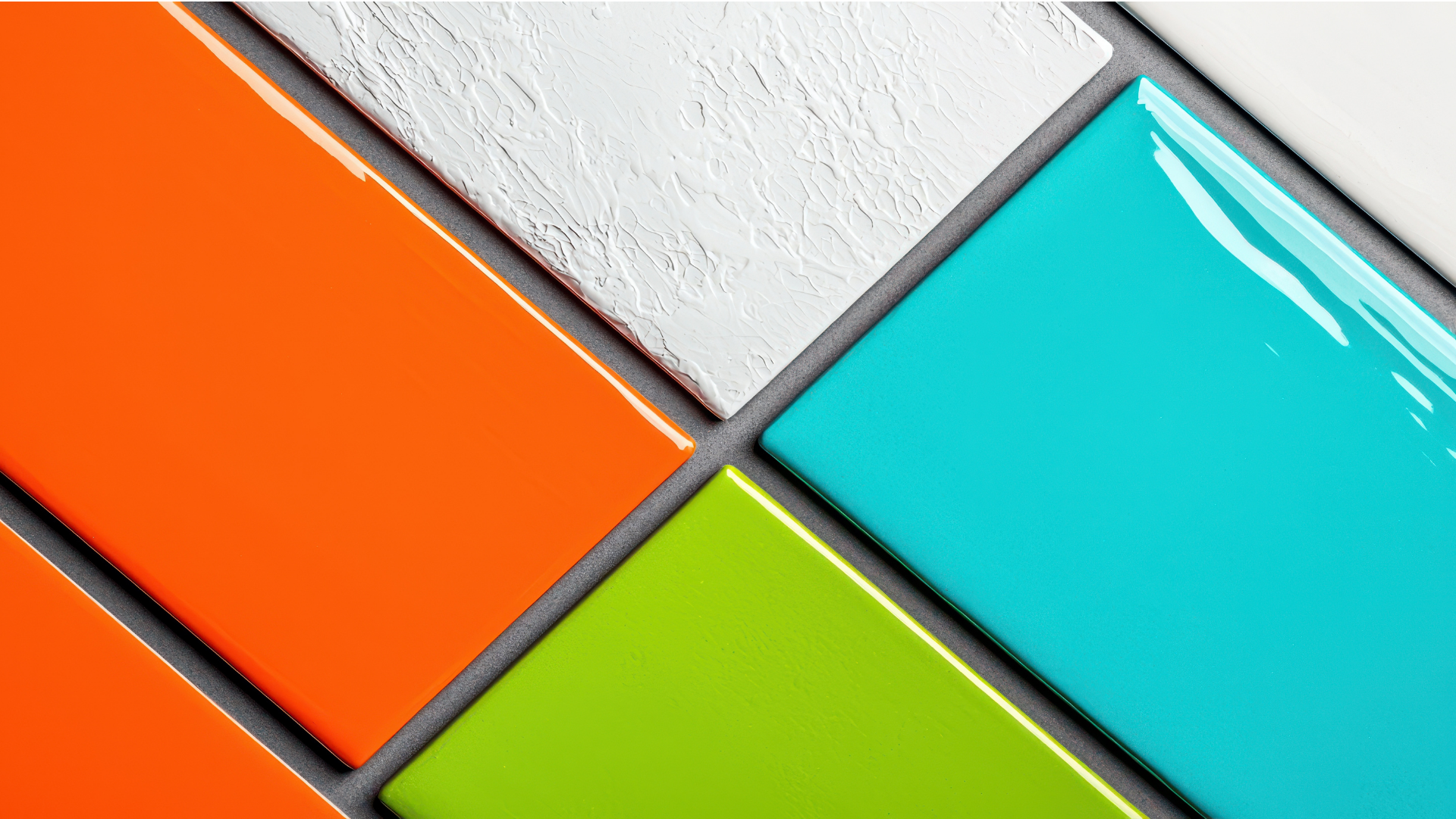 A close up of four different colored tiles on a wall.