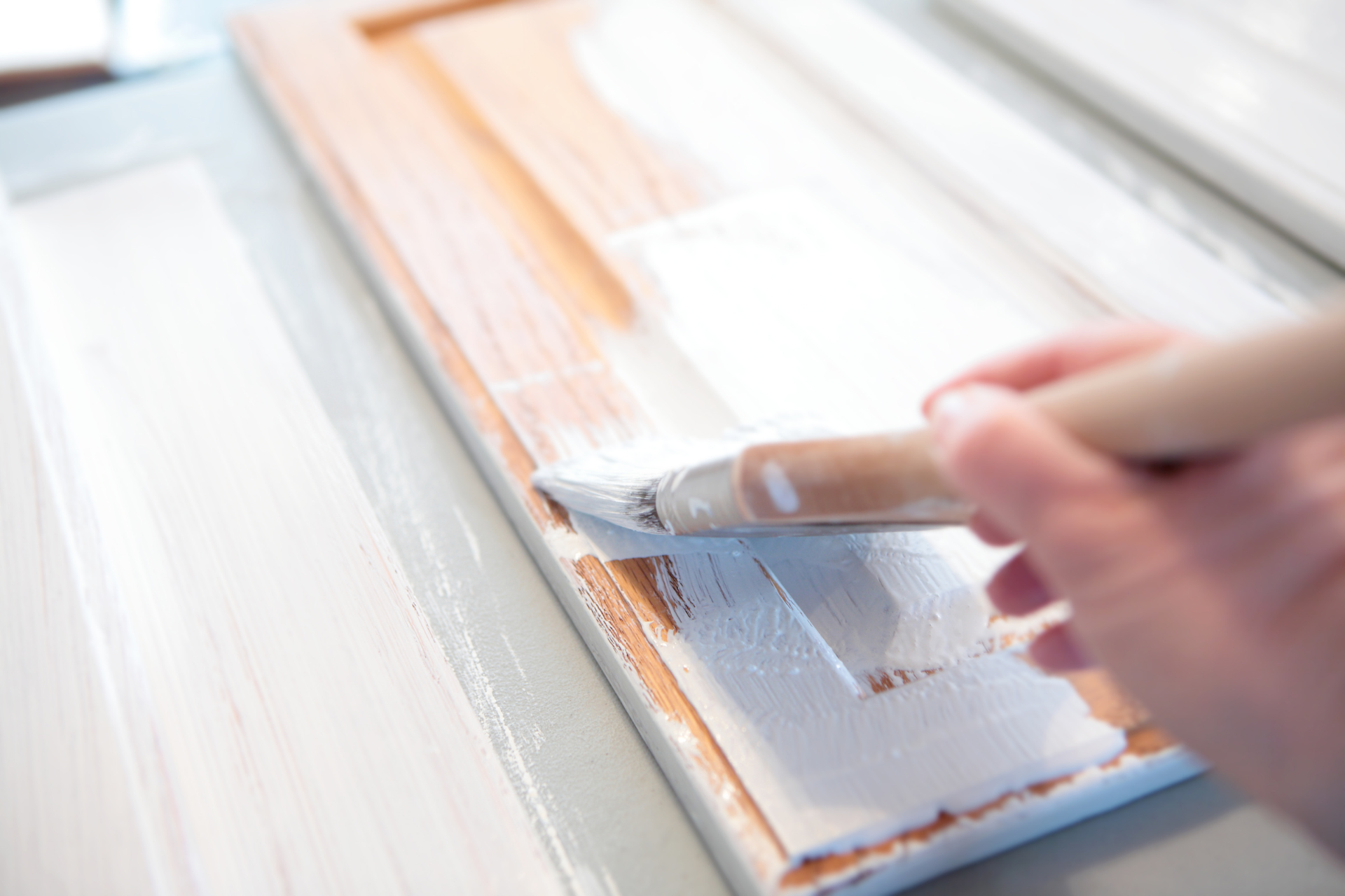A person is painting a piece of wood with a brush.