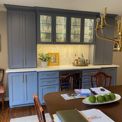 A dining room with blue cabinets and a wooden table