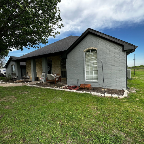 A brick house with a porch and a large window