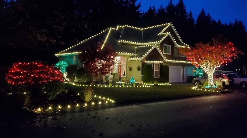 a house is decorated with christmas lights at night .