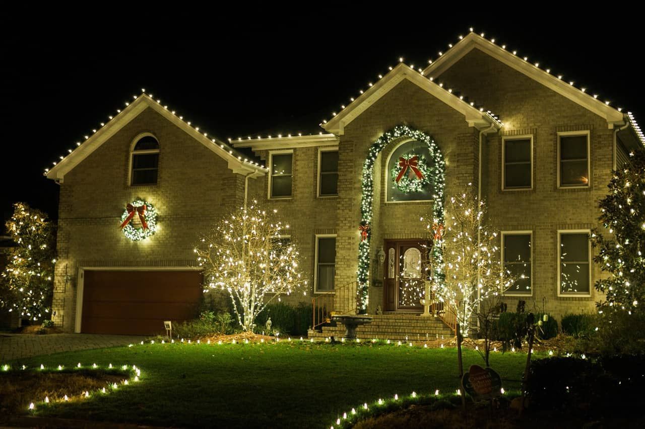a house decorated with christmas lights and a wreath