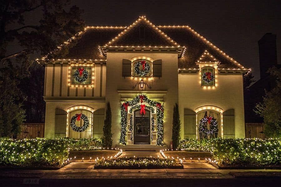 a large house is decorated with christmas lights and wreaths .
