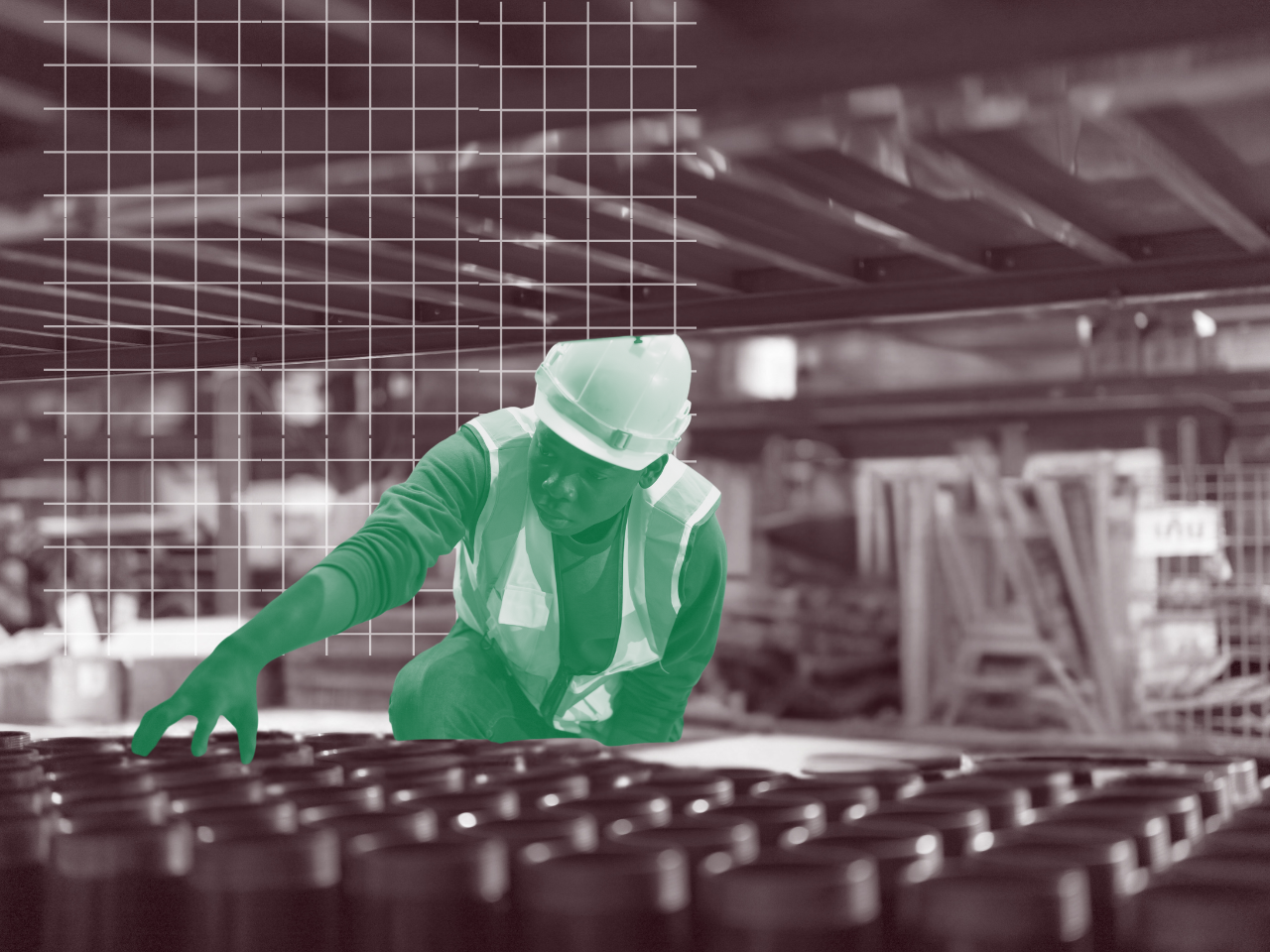 A man wearing a hard hat and safety vest is working in a factory.