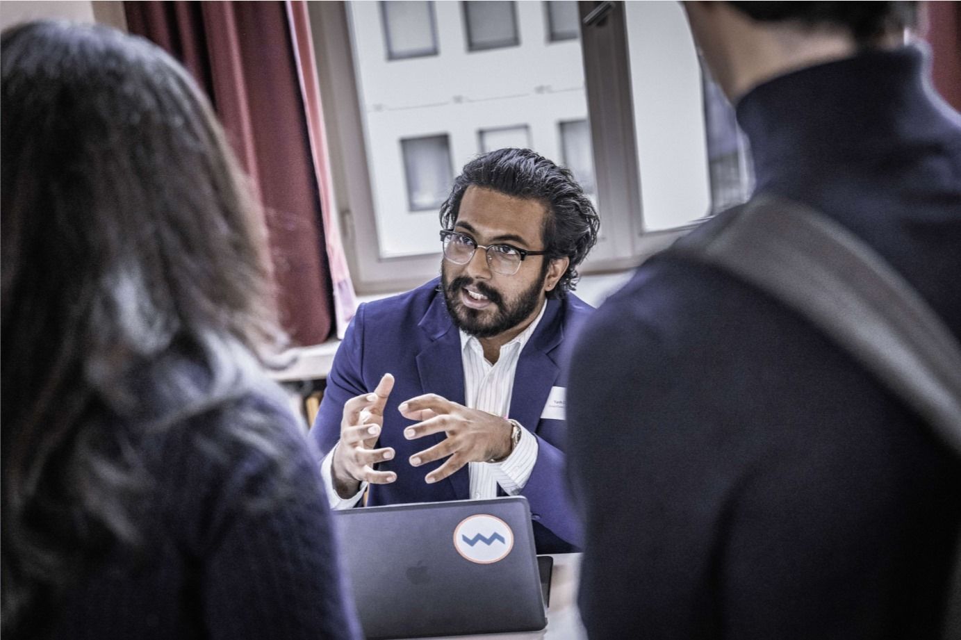 A group of people are putting their hands together in a circle.