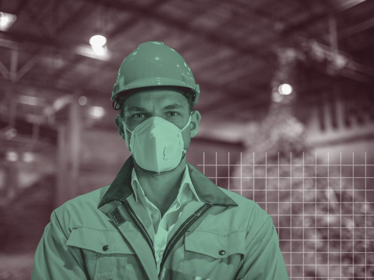 A man wearing a hard hat and a mask in a factory.