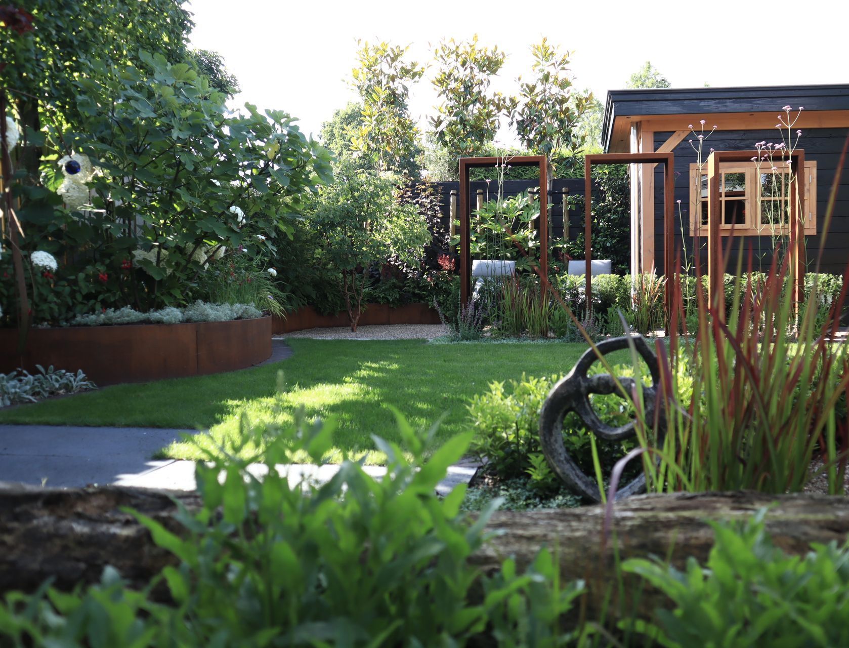 Een huis met een rieten dak is omgeven door bomen en struiken.