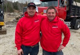 Jonathan et Daniel Sarrazin de DJCO Construction en sweat-shirts rouges posent pour une photo devant un camion rouge.