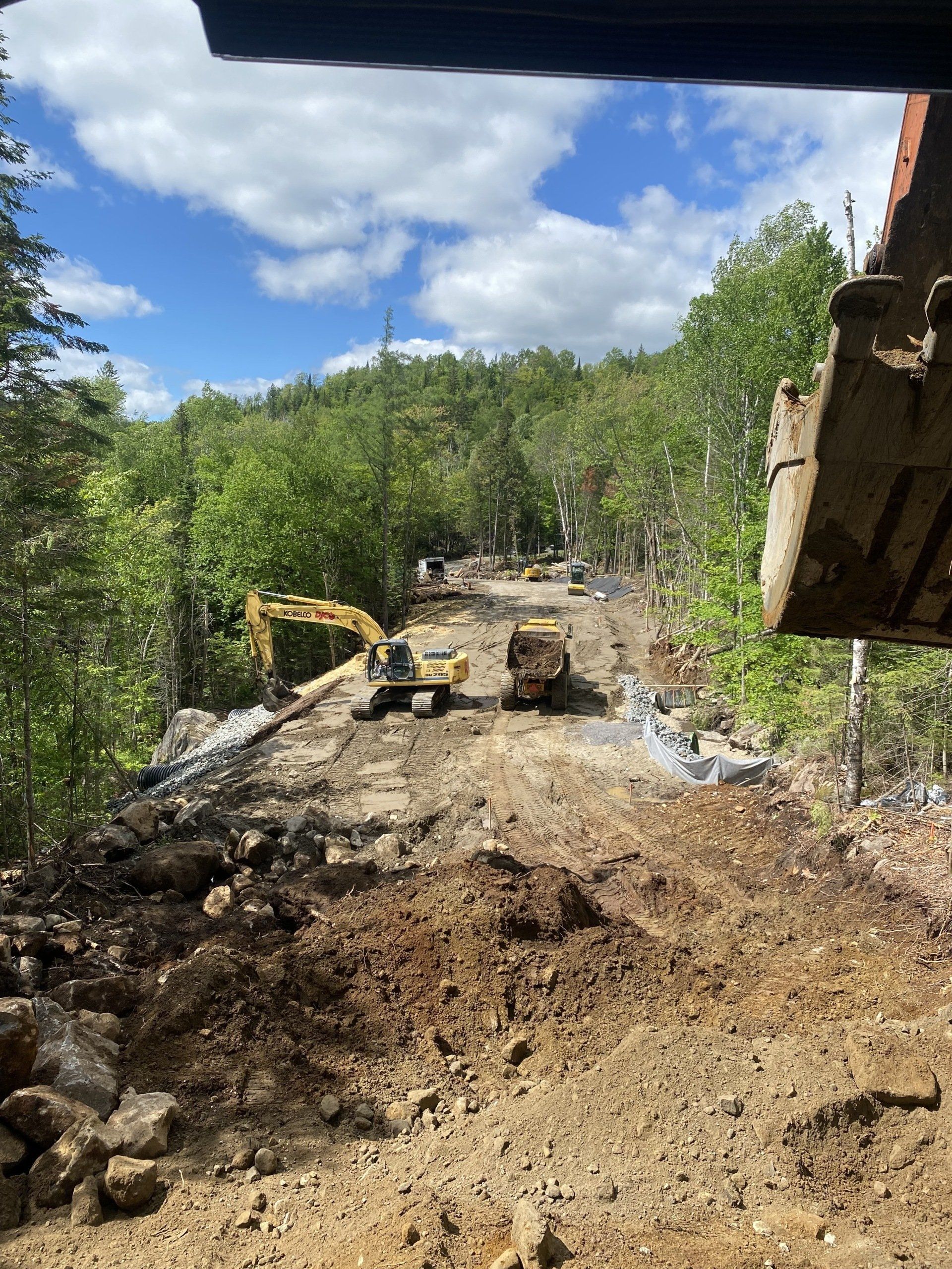 un chantier de construction avec beaucoup de terre et d arbres en arrière-plan.
