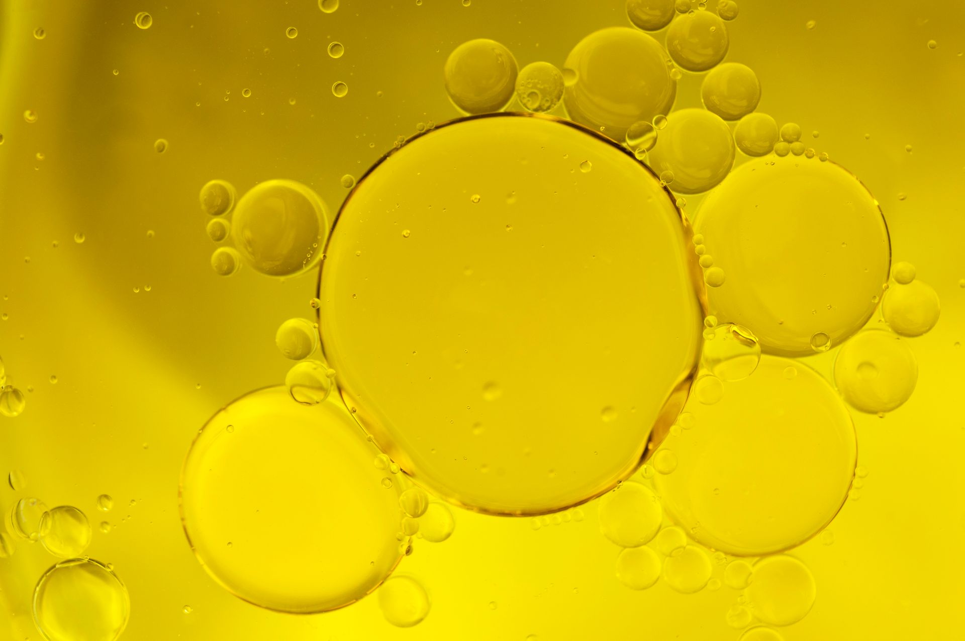 Yellow oil droplets floating against a yellow background.