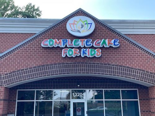 A red brick building exterior featuring a colorful sign that reads 