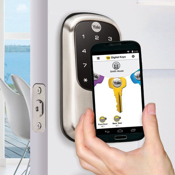 Person unlocking smart door lock with a smartphone displaying key and door names.