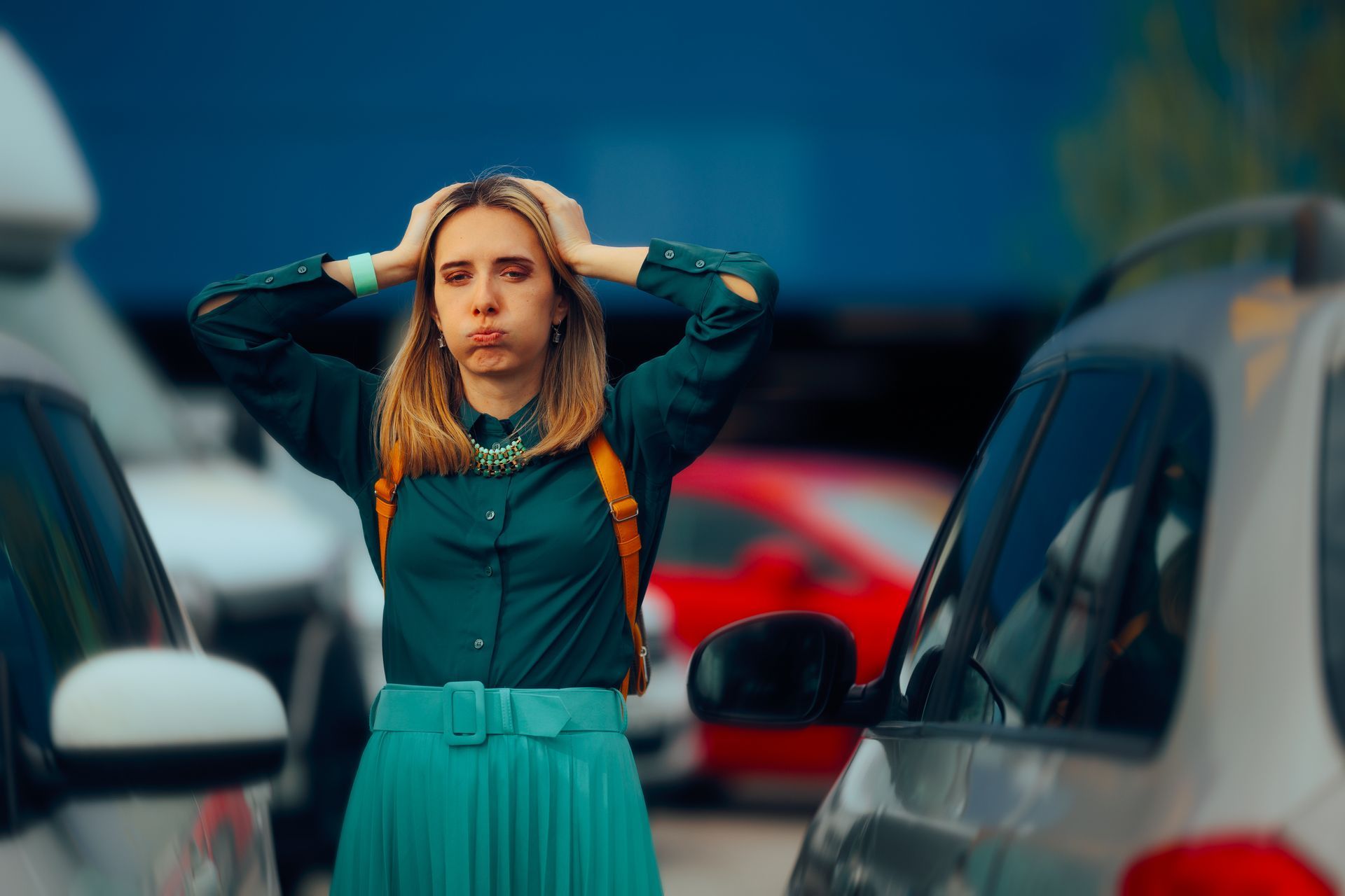 A woman standing in a parking lot with her hands on her head after getting locked out of her car