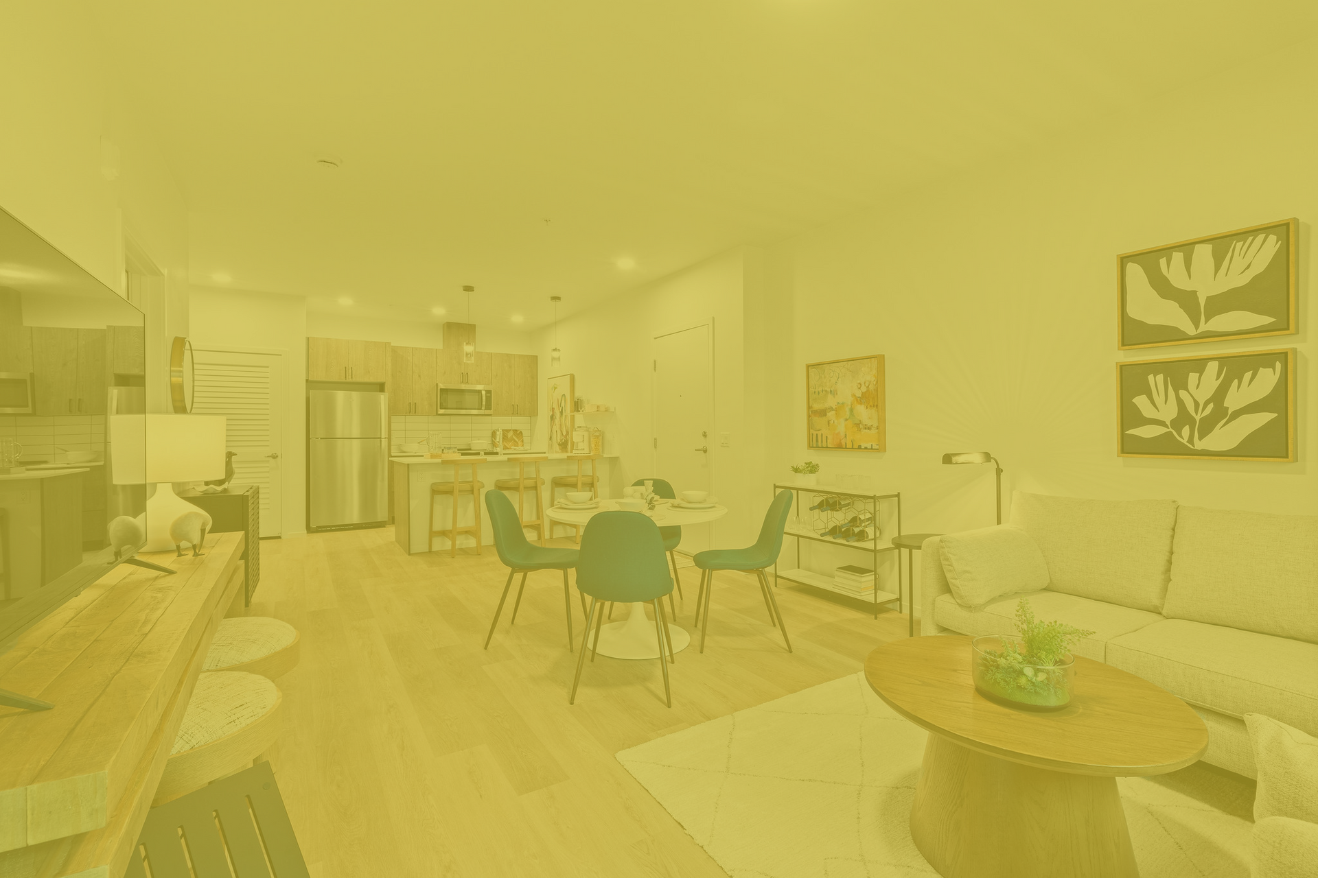 A living room with a couch , table , chairs and a yellow background.