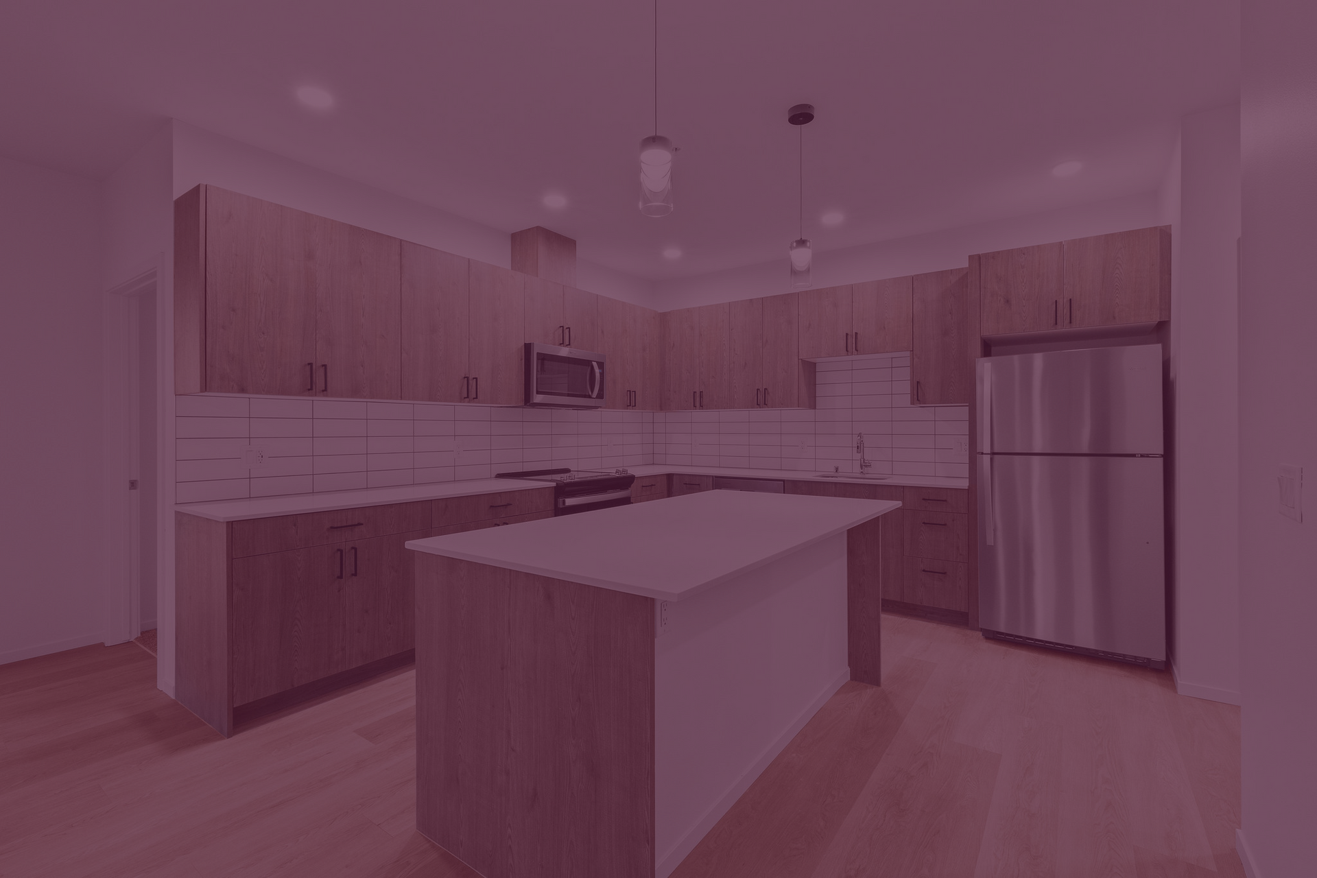 A kitchen with wooden cabinets , stainless steel appliances , and a large island.