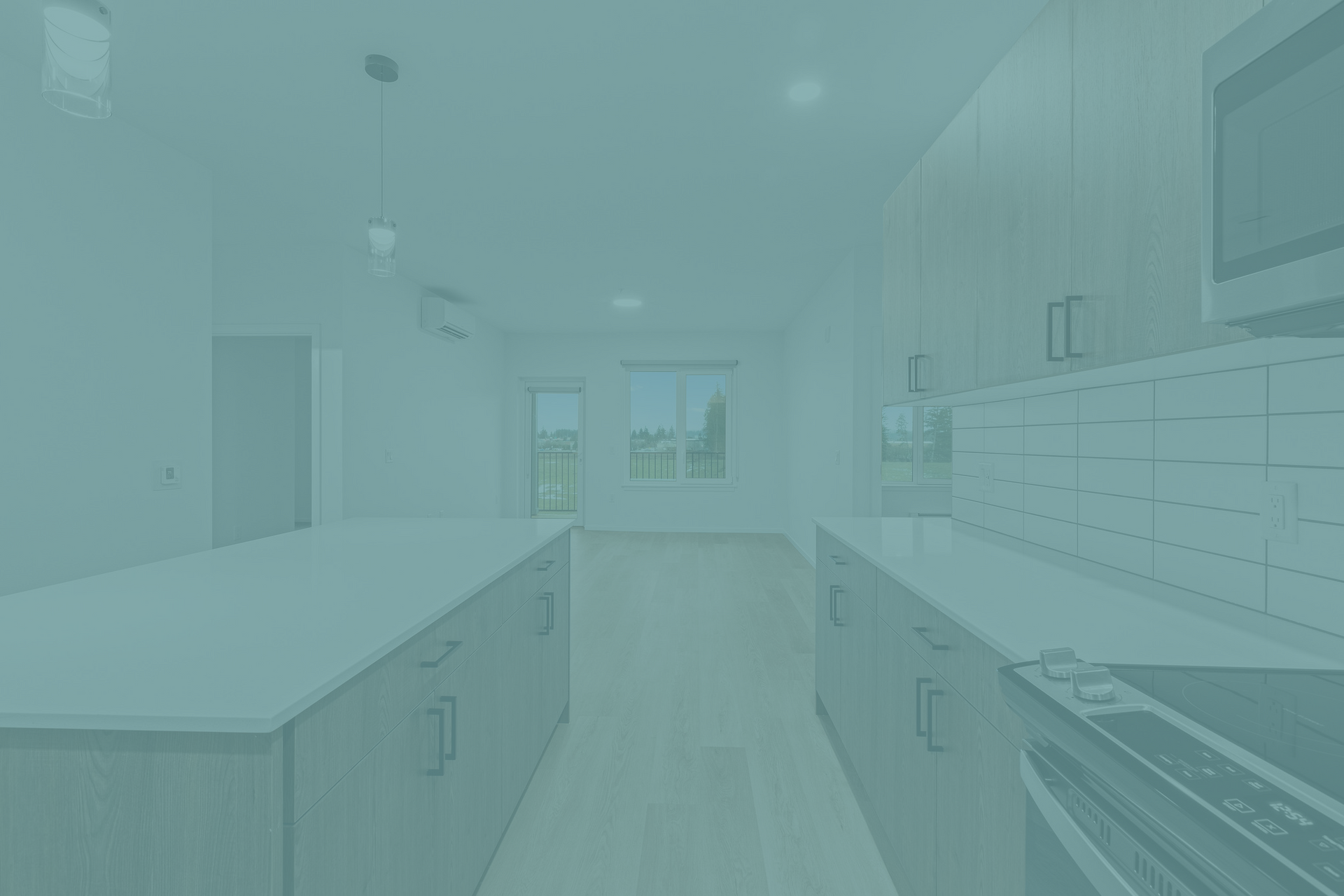 An empty kitchen with white cabinets , a microwave , and a stove.