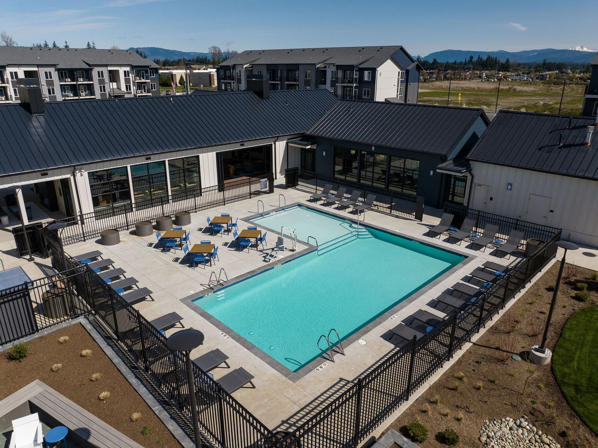 An aerial view of a large swimming pool surrounded by chairs and tables.