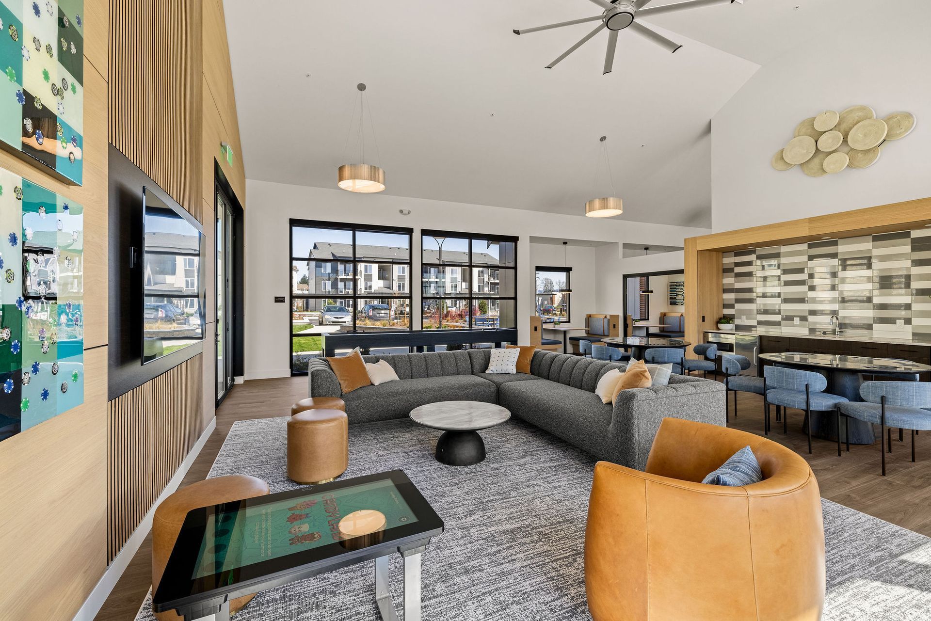 A living room with a lot of furniture and a ceiling fan.
