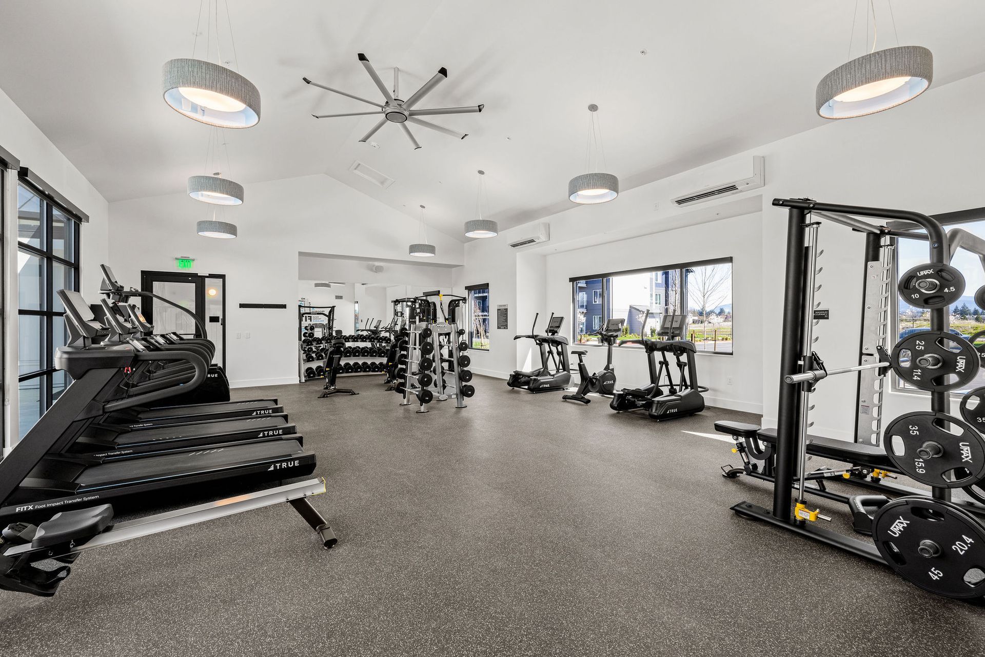 A large gym filled with lots of exercise equipment.