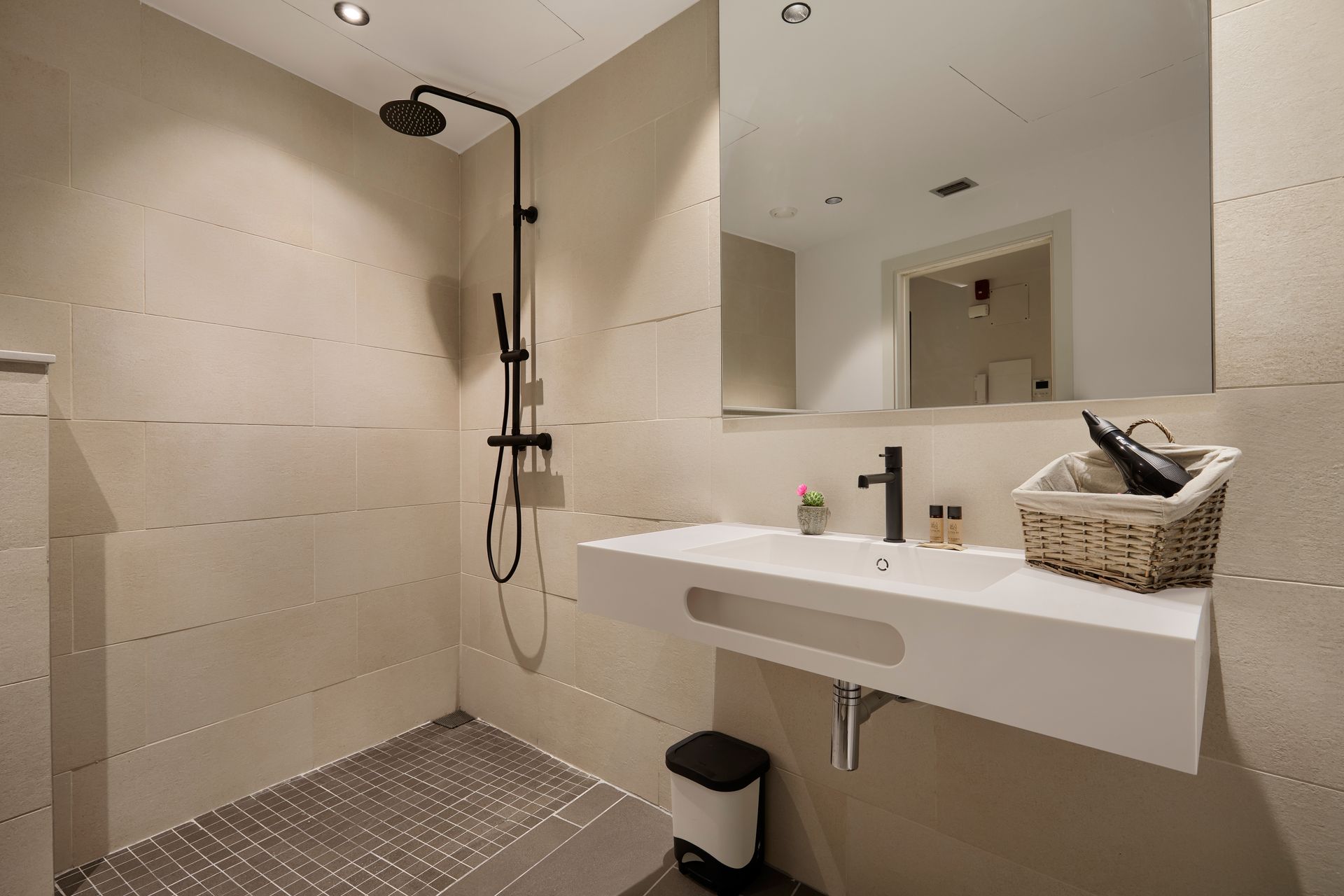 A bathroom with a sink , mirror and walk in shower.