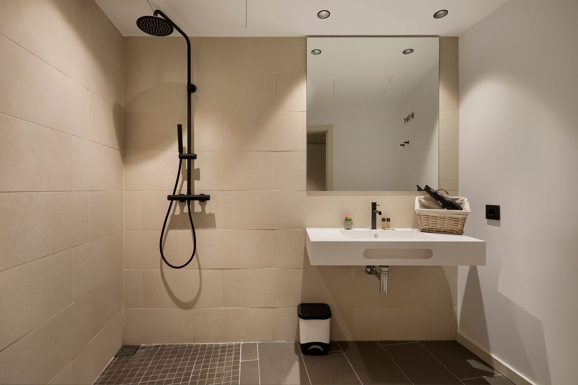 A bathroom with a sink a shower and a mirror