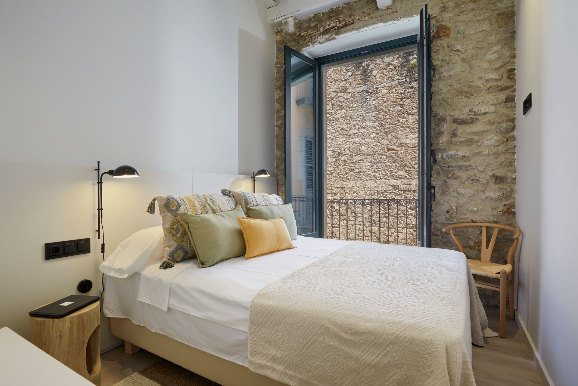 A bedroom with a large bed and a brick wall.