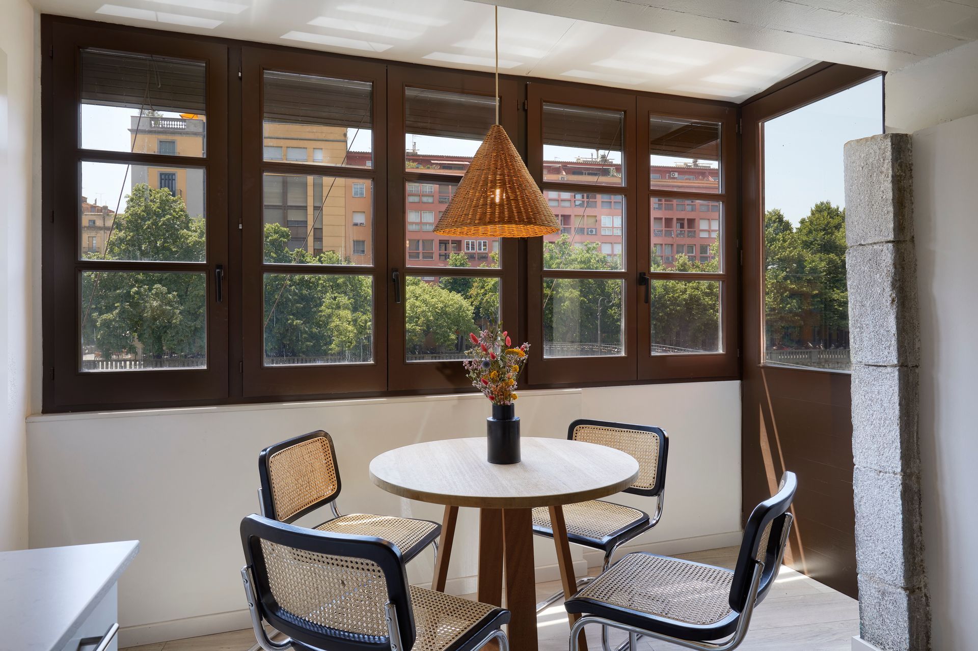 A room with a table and chairs in front of a window