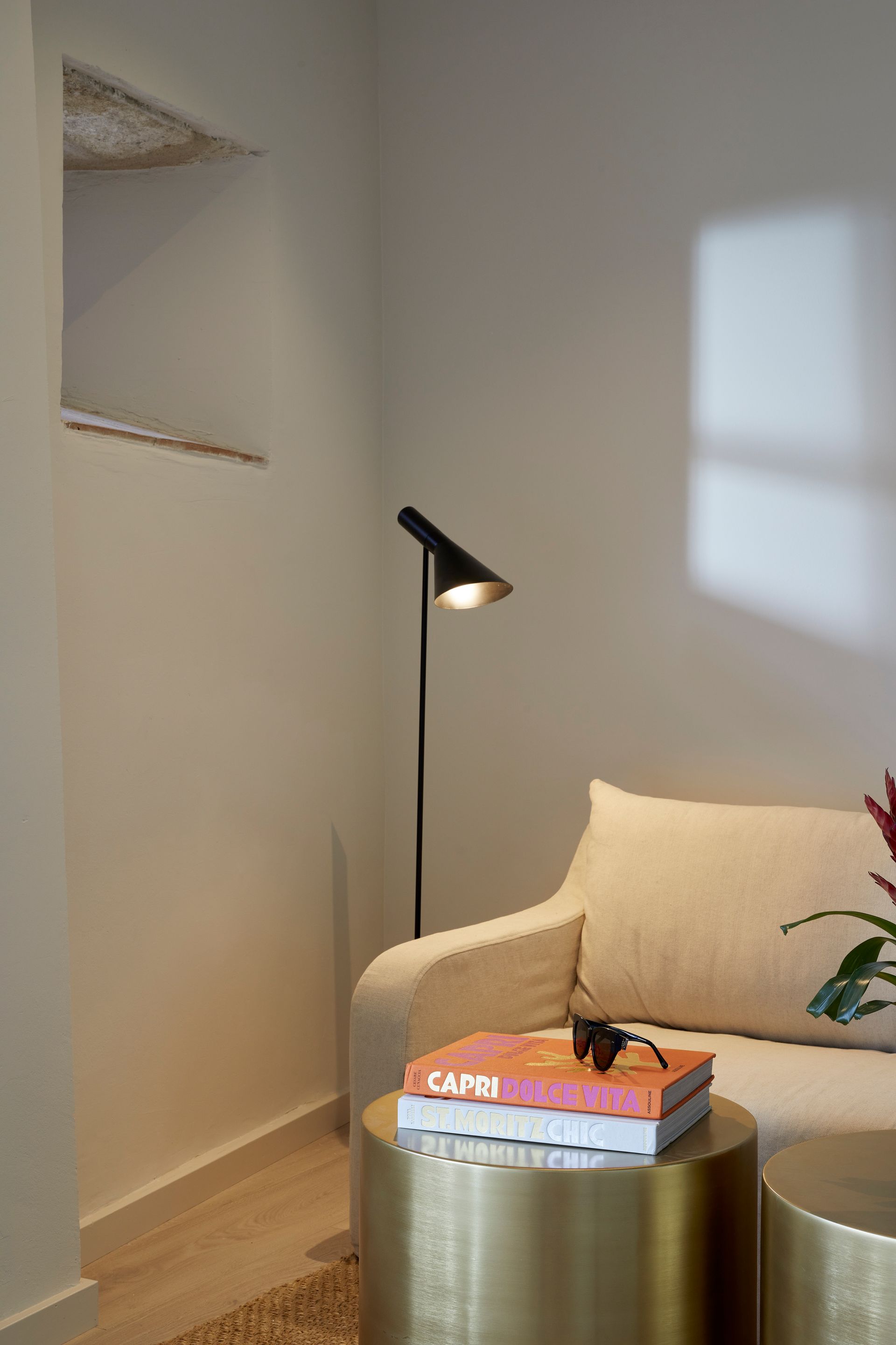 A living room with a couch , two tables , and a lamp.