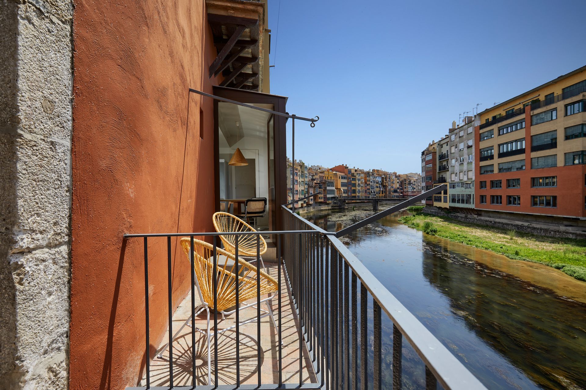 A balcony overlooking a river with buildings in the background