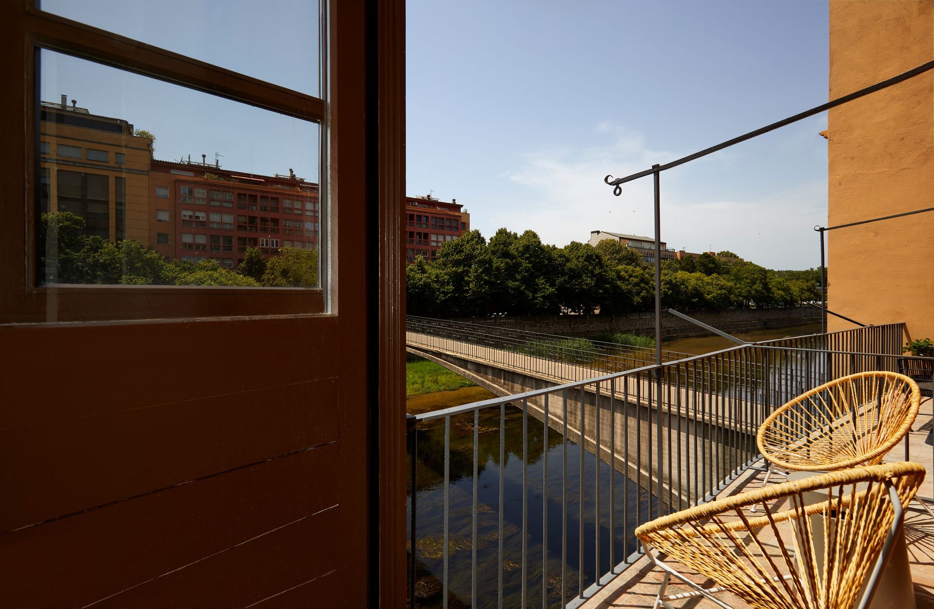 A balcony with a chair and a view of a river