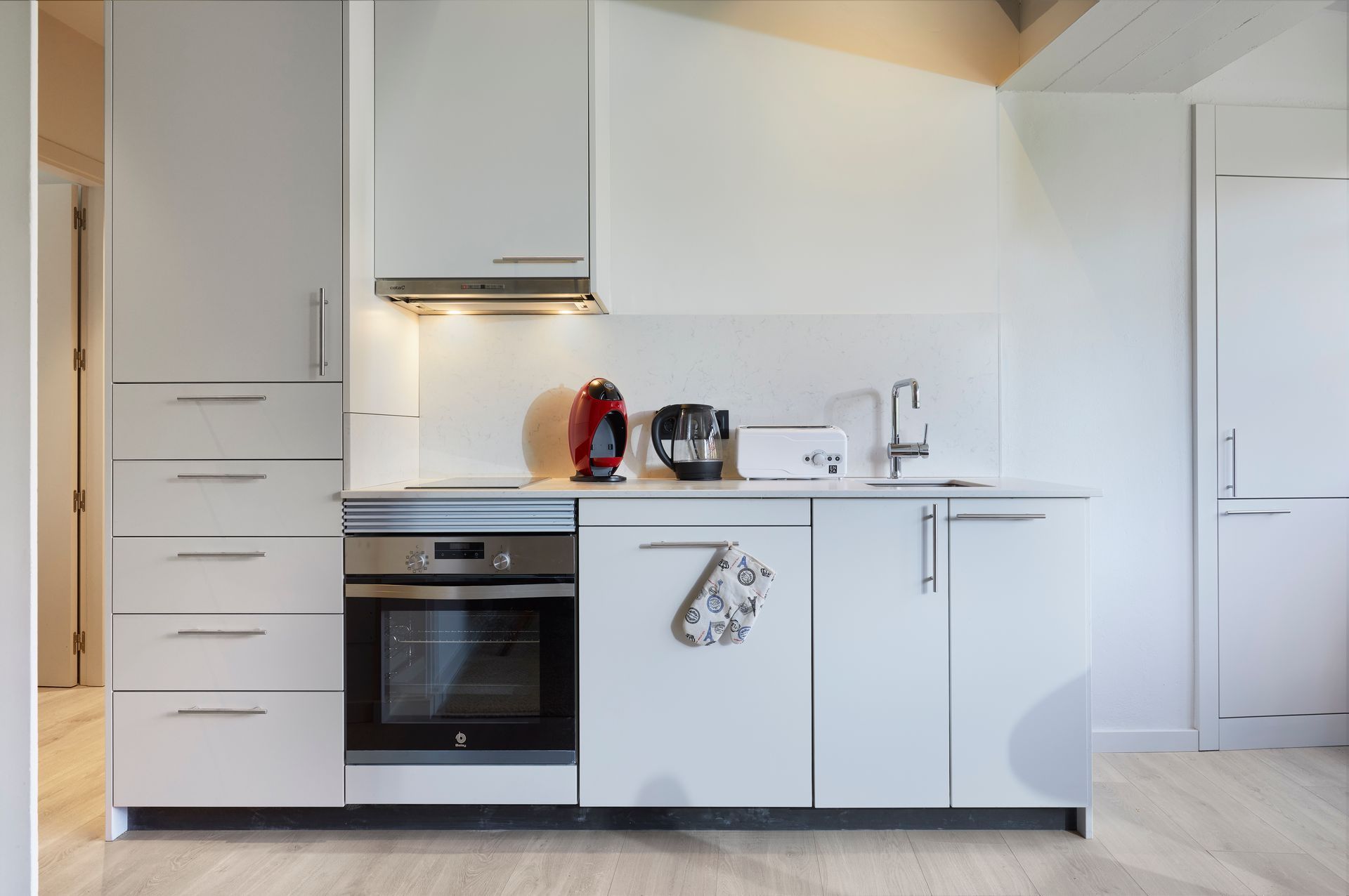 A kitchen with white cabinets and black appliances