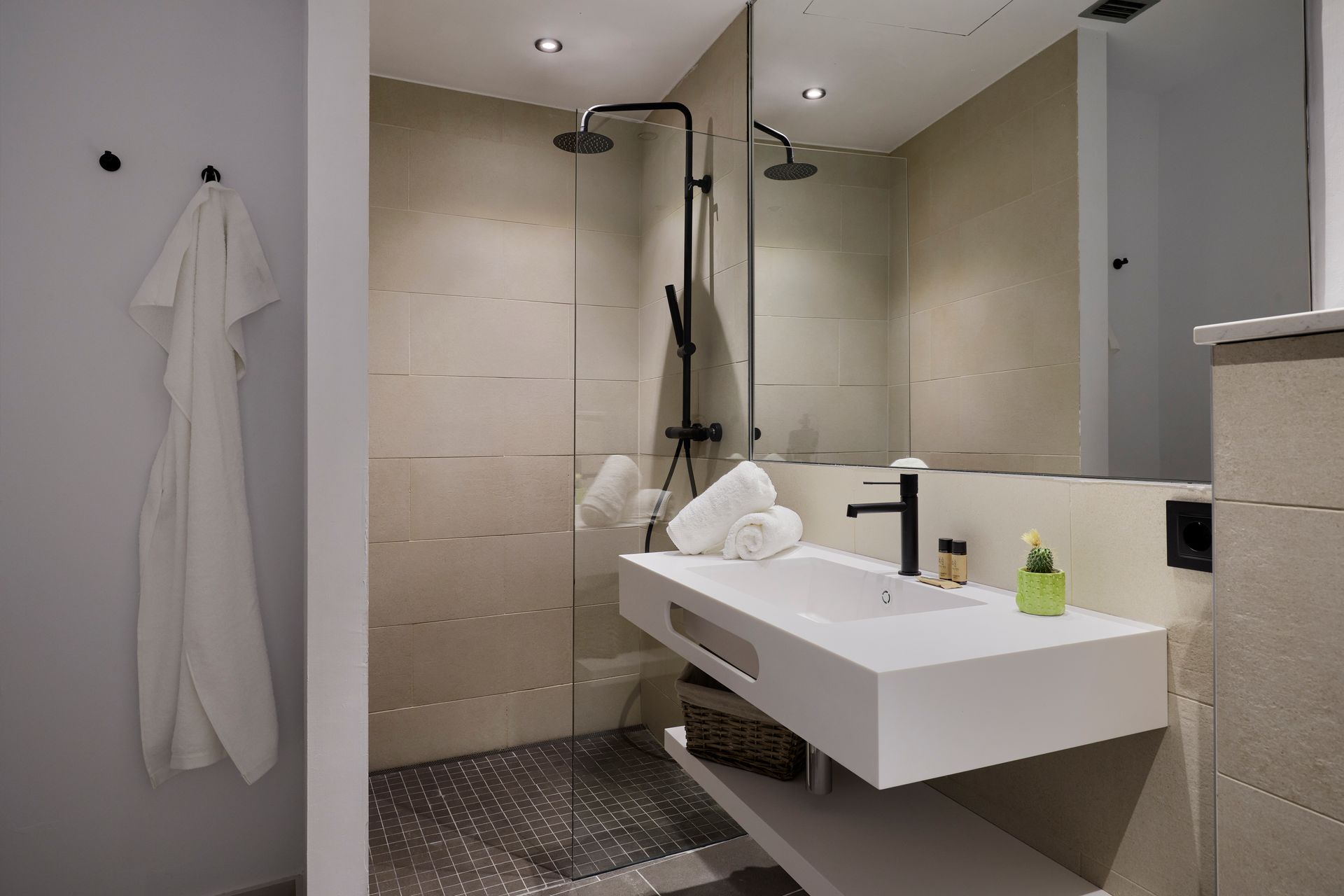 A bathroom with a sink , mirror and shower.