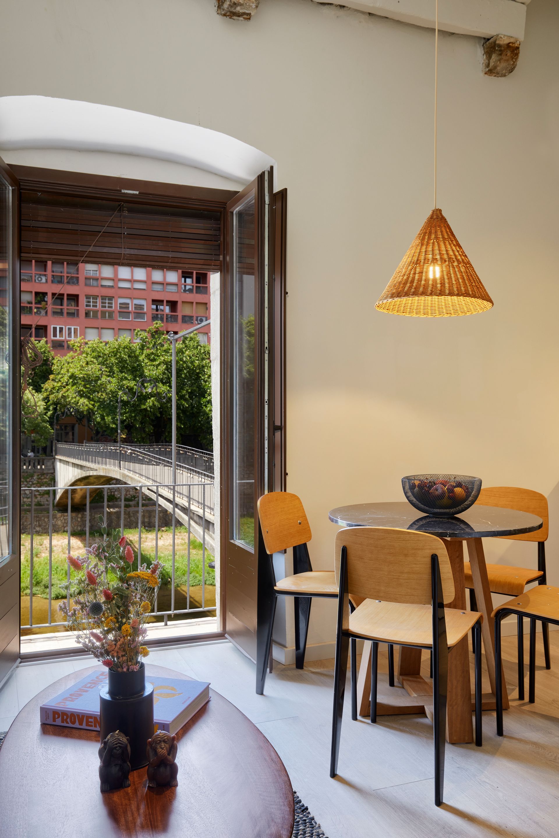 A living room with a table and chairs and a view of a bridge