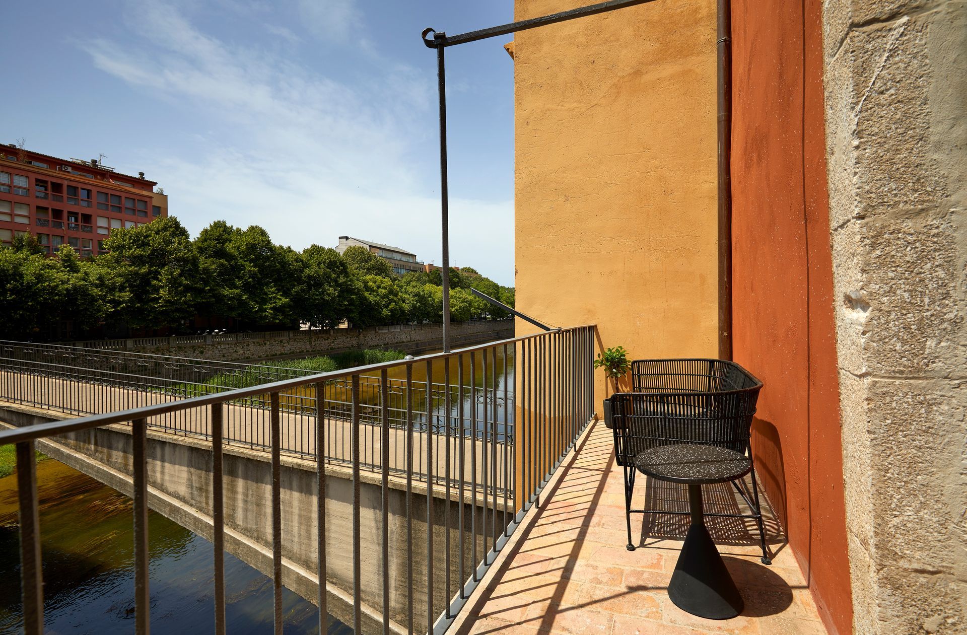 A balcony with a table and chairs overlooking a river
