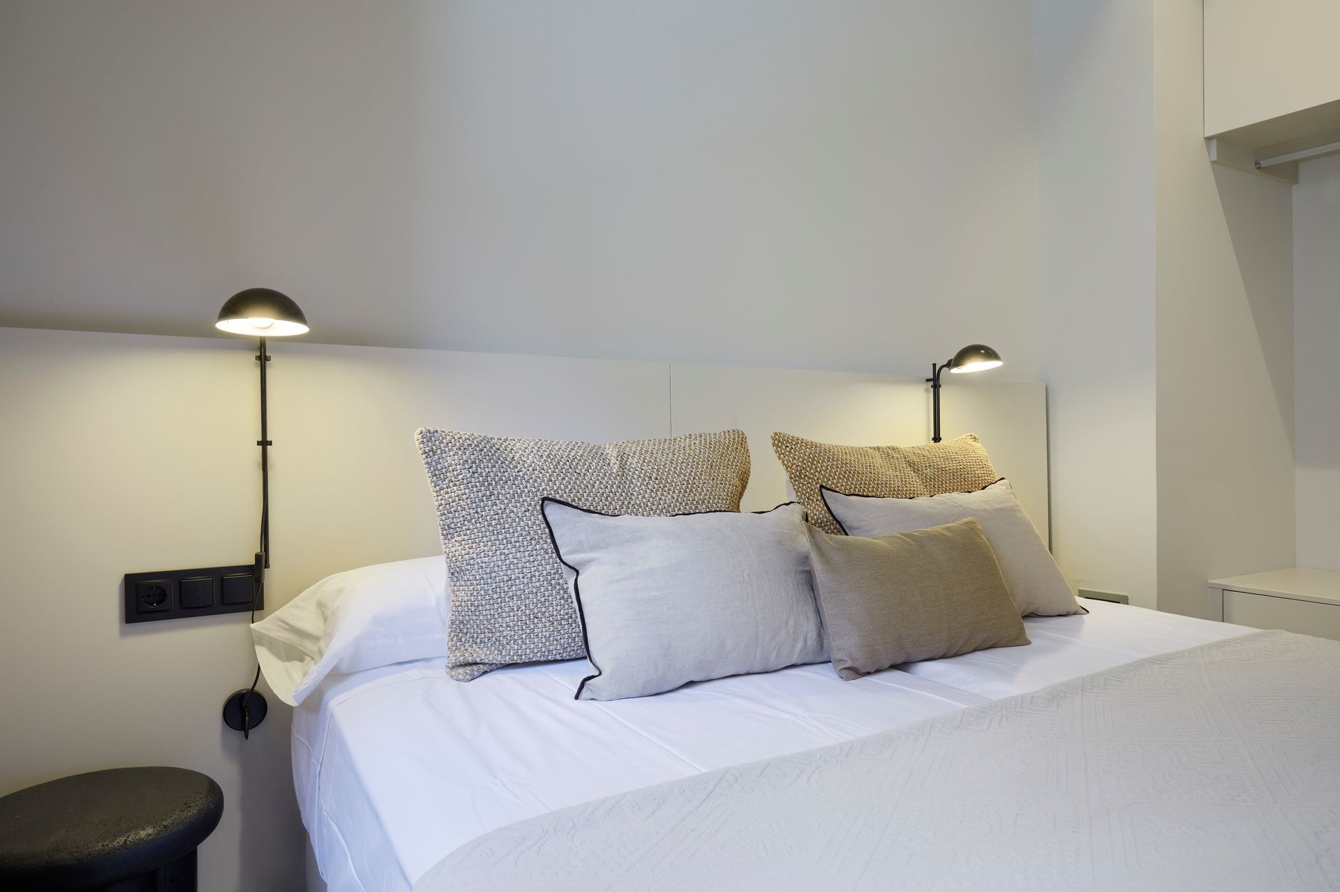 A bed with white sheets and pillows in a bedroom.