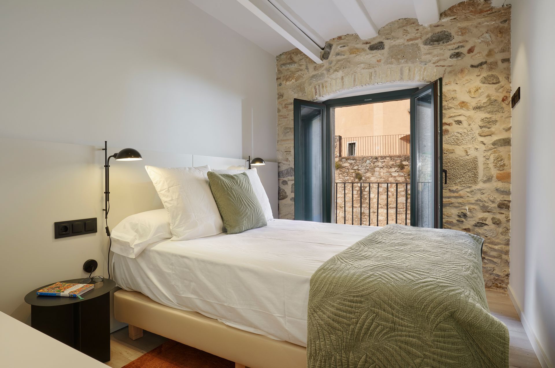 A bedroom with a large bed and a balcony