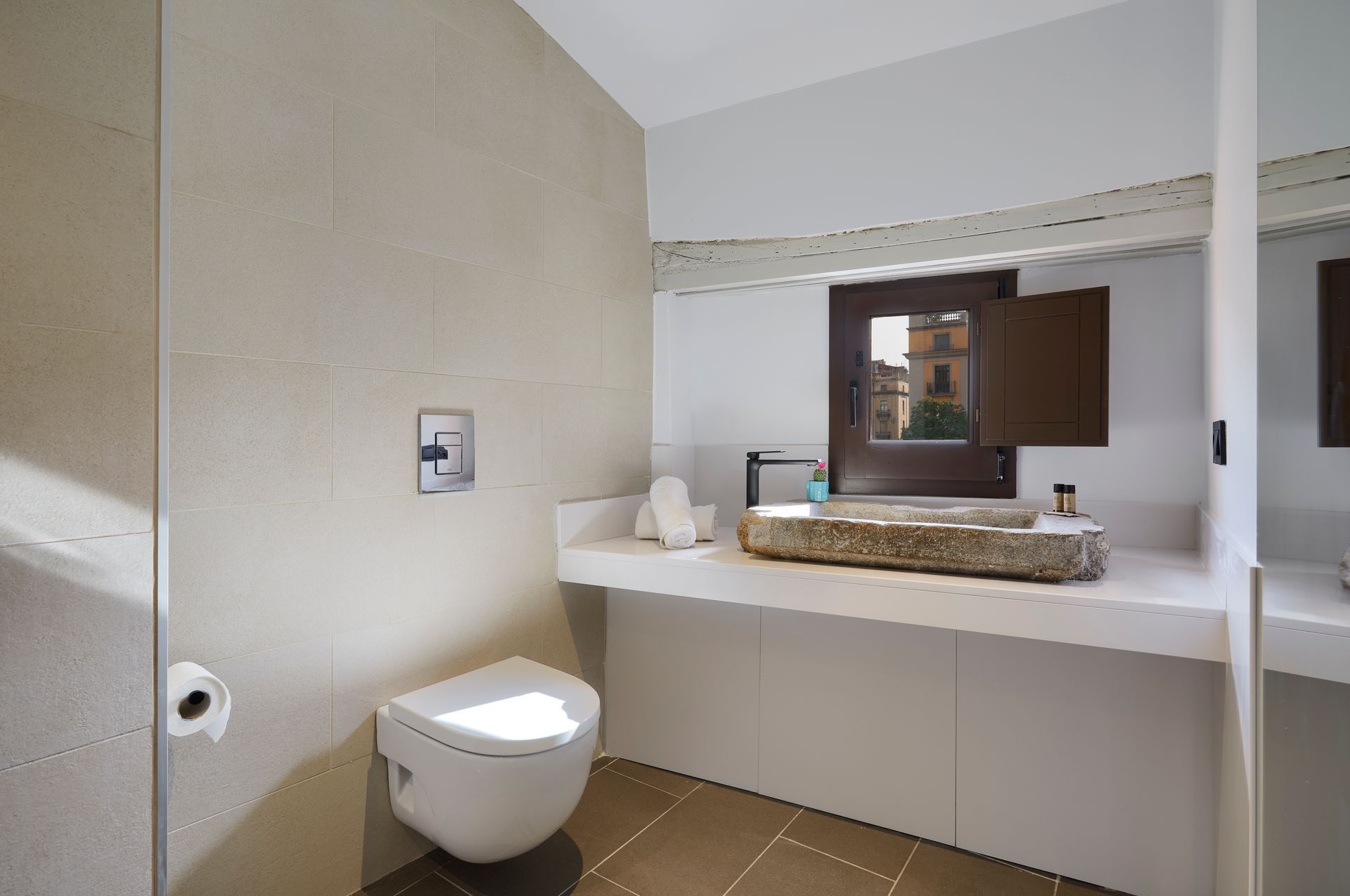 A bathroom with a toilet , sink and mirror.