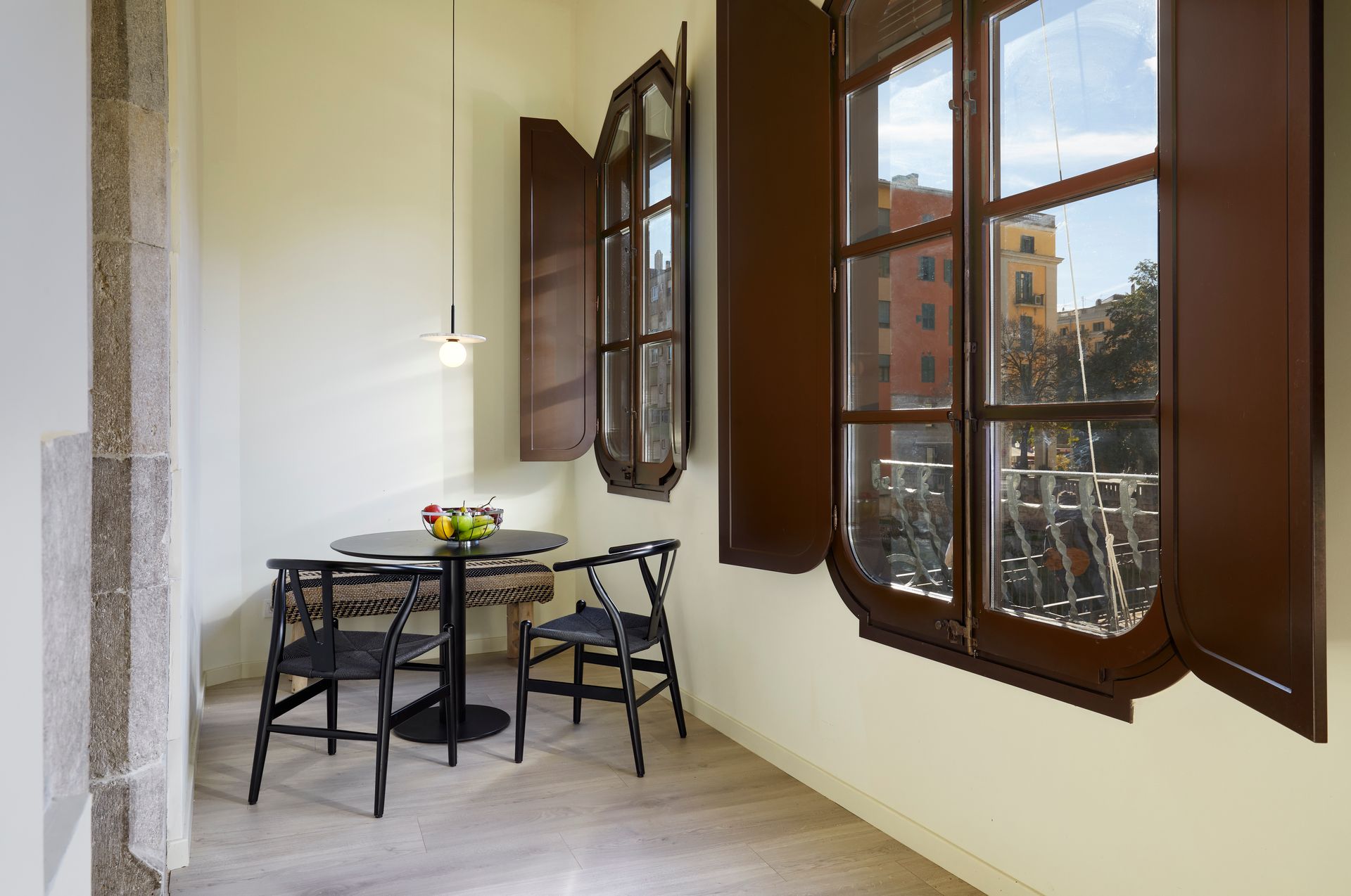 A room with a table and chairs and two windows