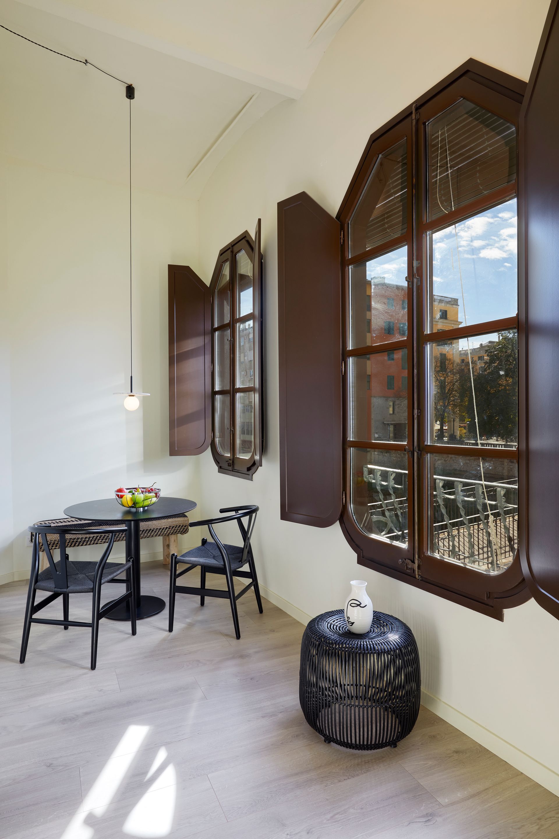 A room with a table and chairs and two windows