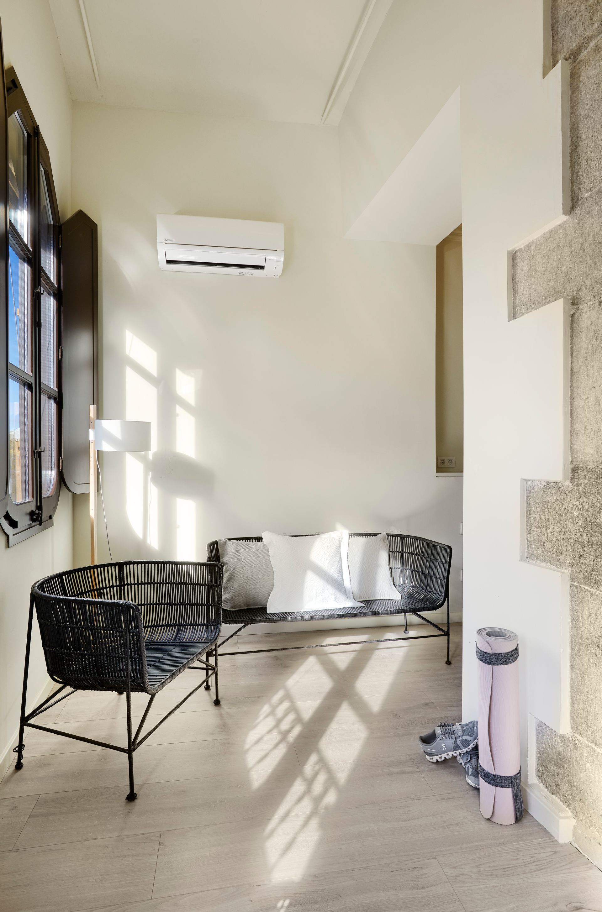 A living room with a couch and chairs and a yoga mat on the floor