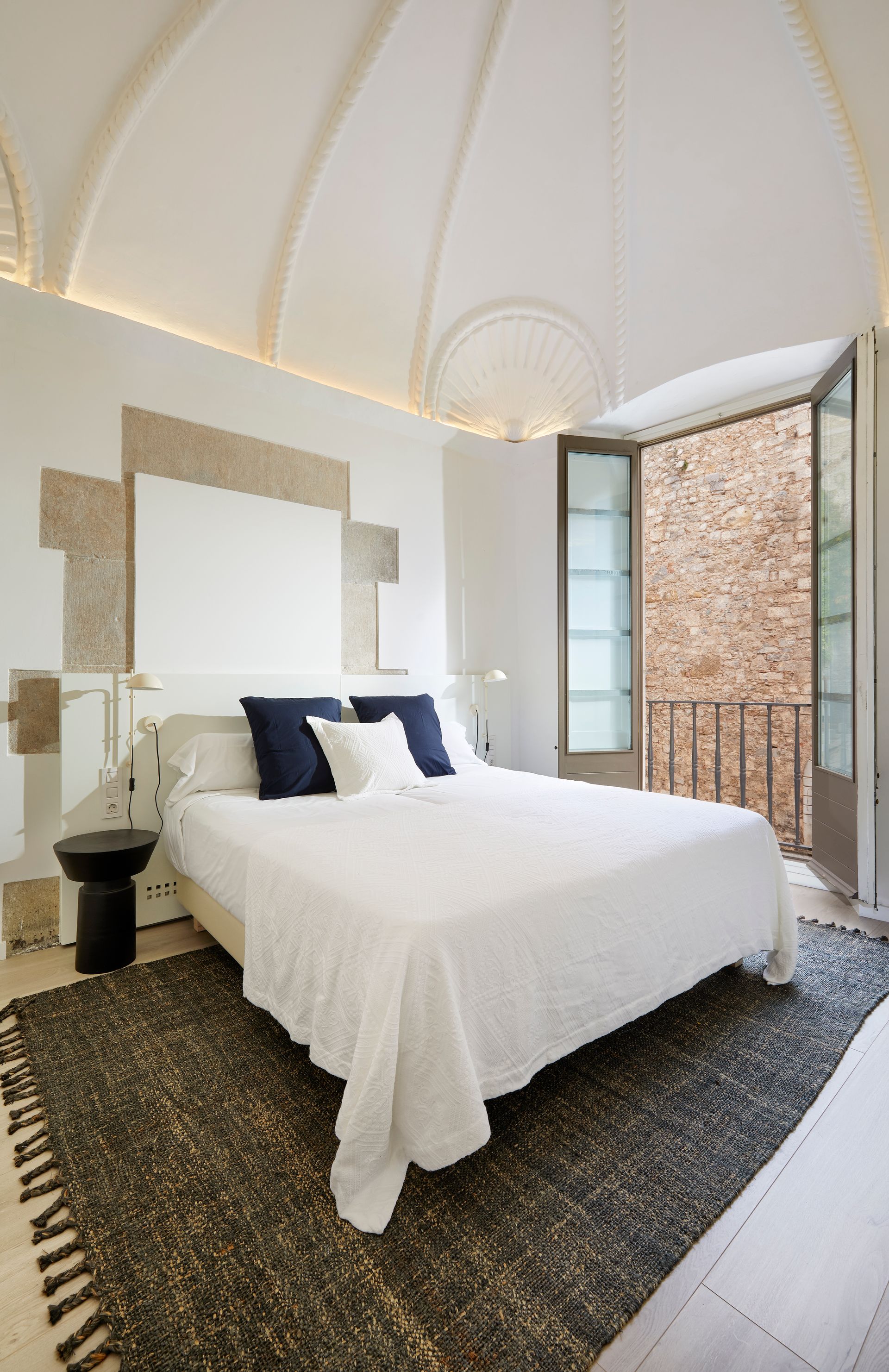 A bedroom with a large bed and a balcony.