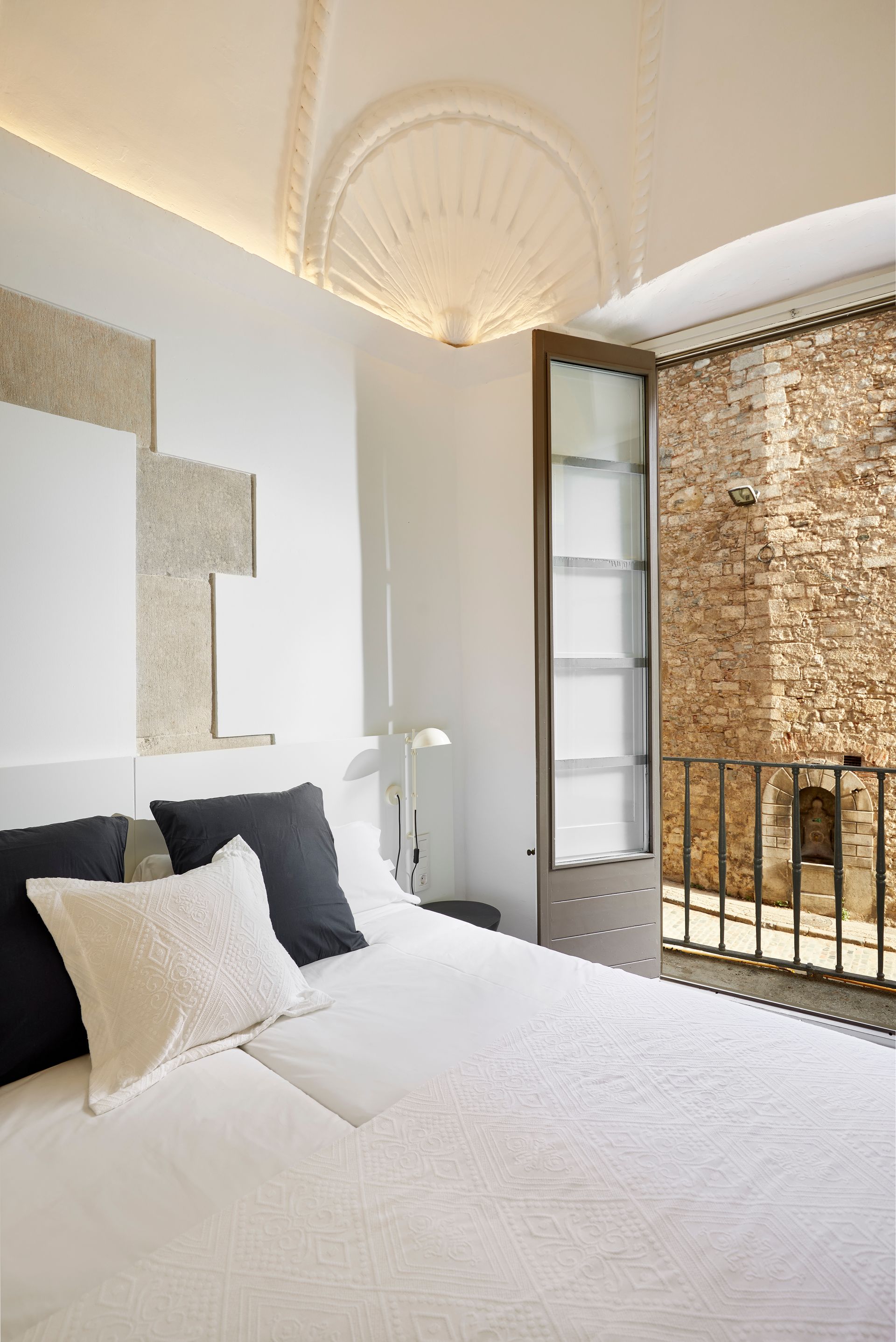 A bedroom with a bed and a brick wall