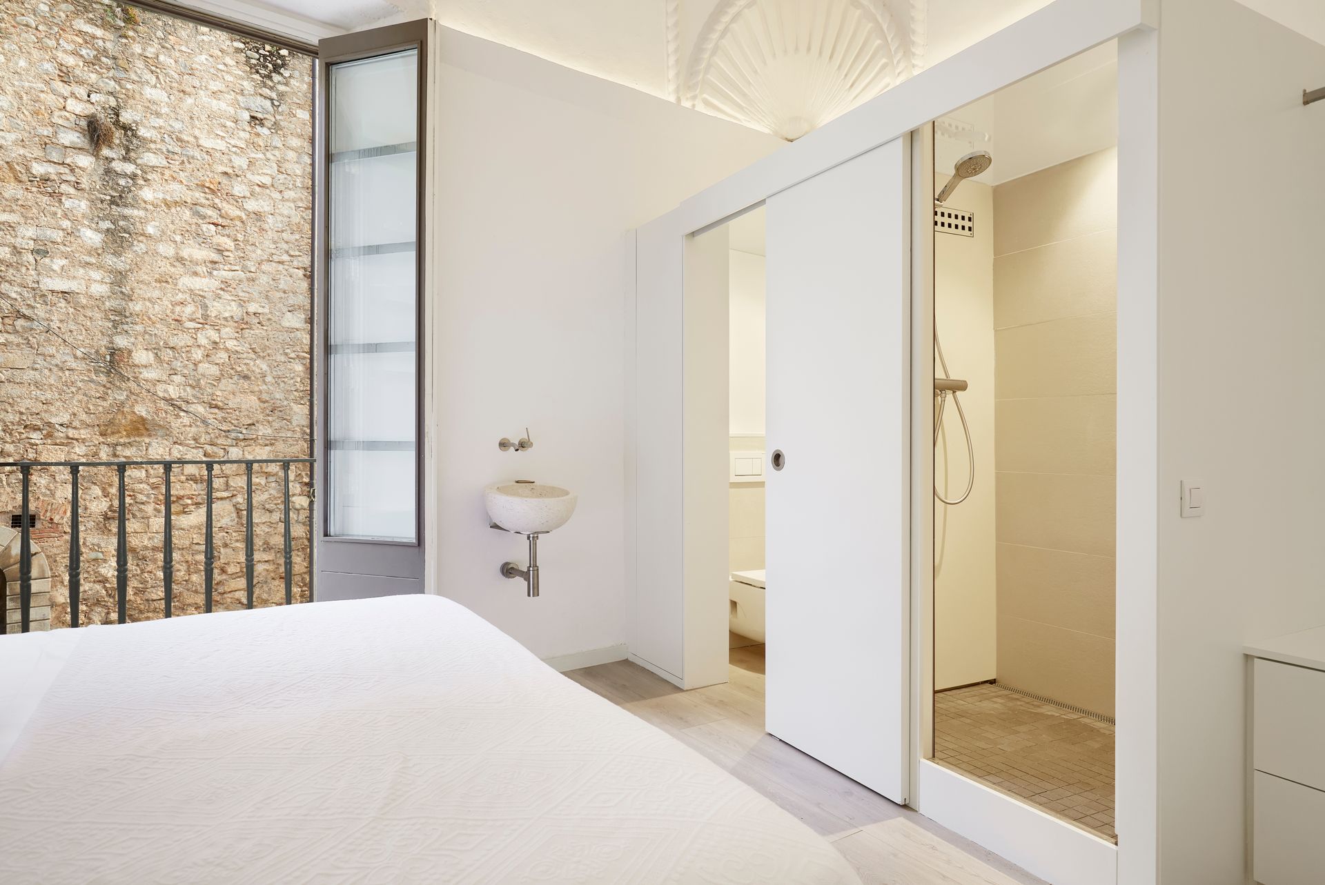 A bedroom with a sliding glass door leading to a bathroom