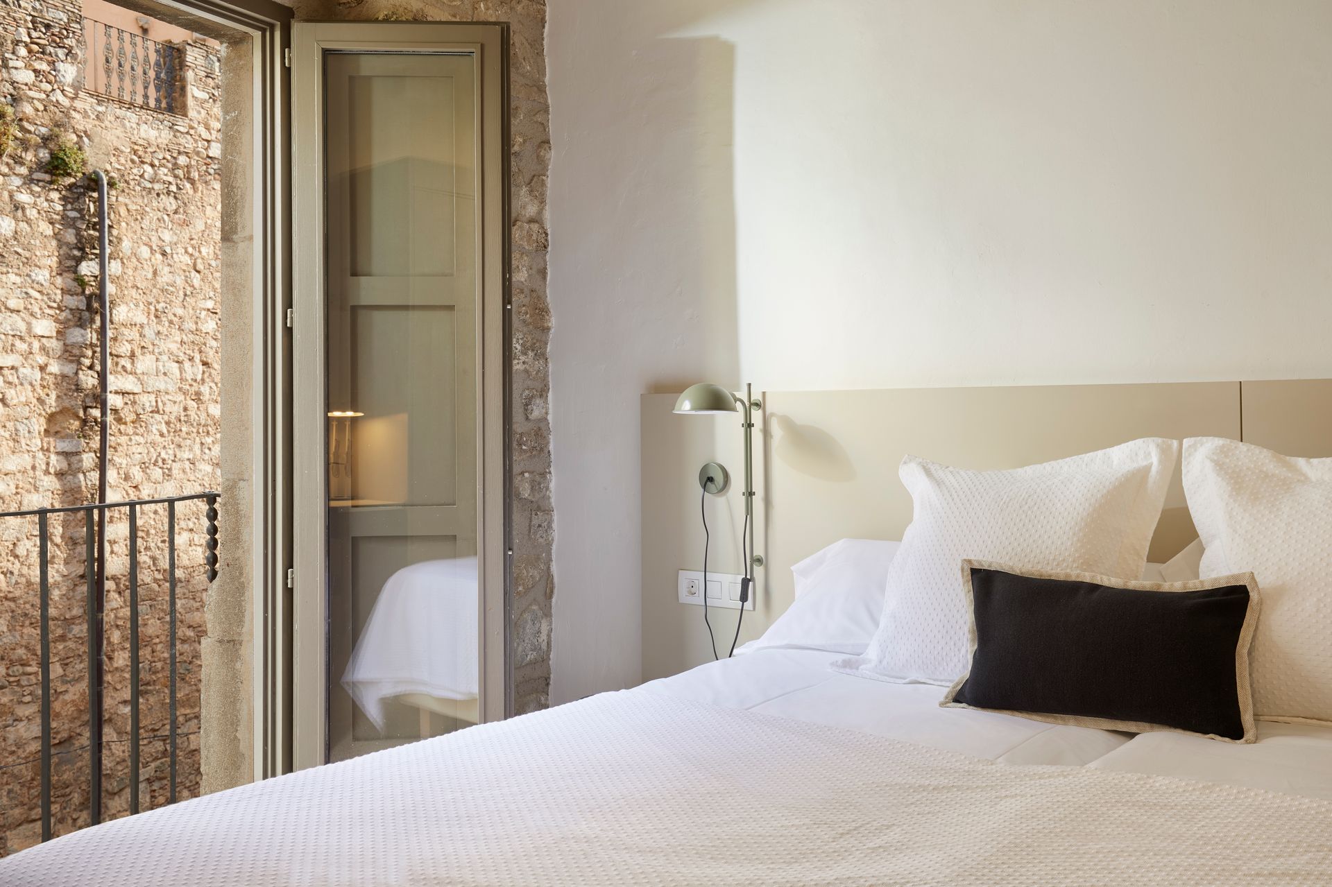 A bedroom with a large bed and a balcony