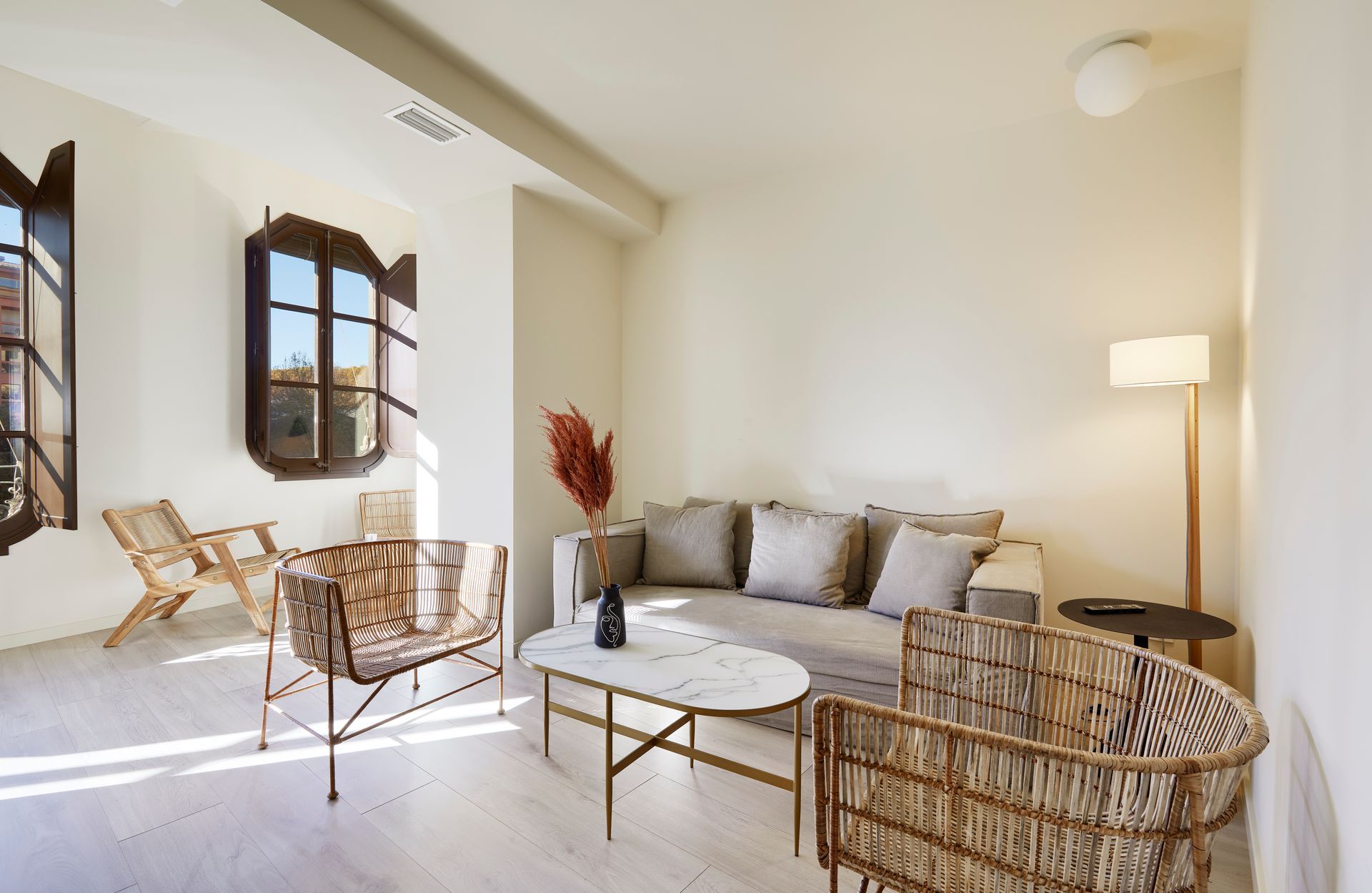 A living room with a couch , chairs , and a coffee table.