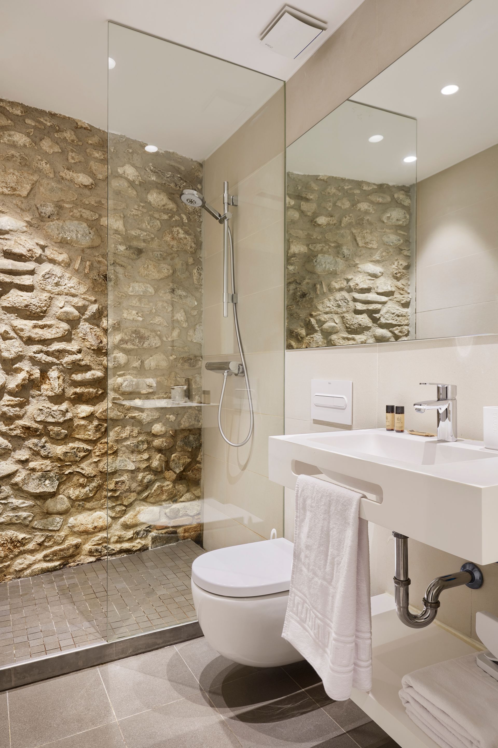 A bathroom with a toilet , sink and shower.