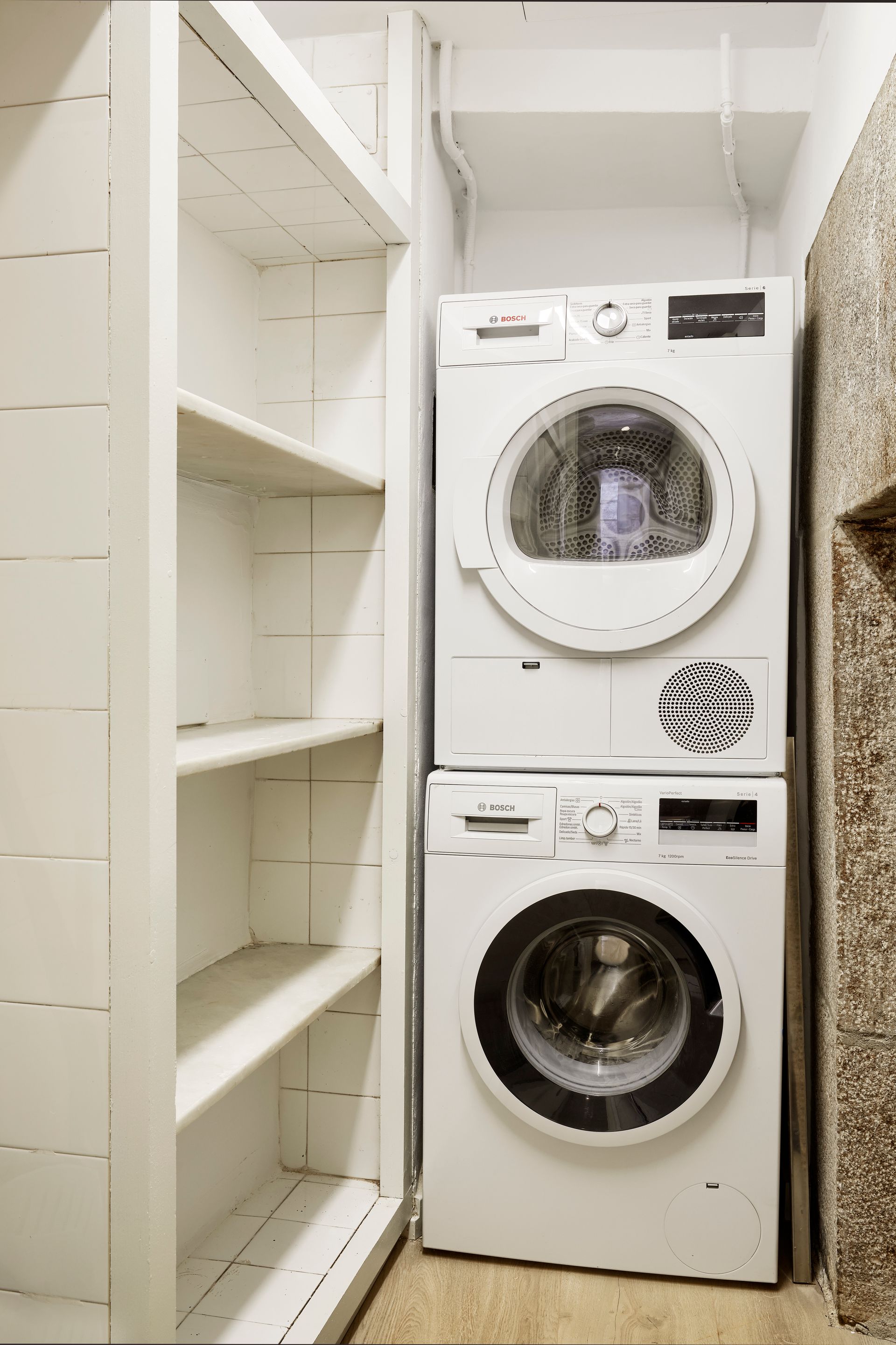 A washer and dryer are stacked on top of each other in a laundry room.